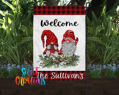 A banner featuring a red and white gnome design with a wreath of greenery and pine cones, set against a backdrop of lush greenery and flowers.