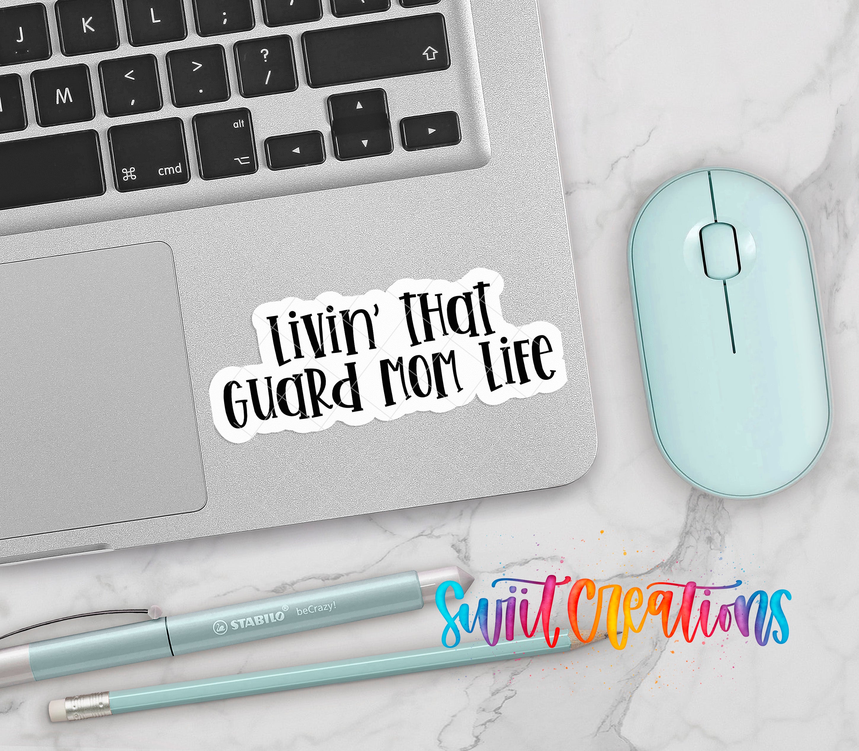 a laptop, a mouse, and some writing utensils, all placed on a marble surface.