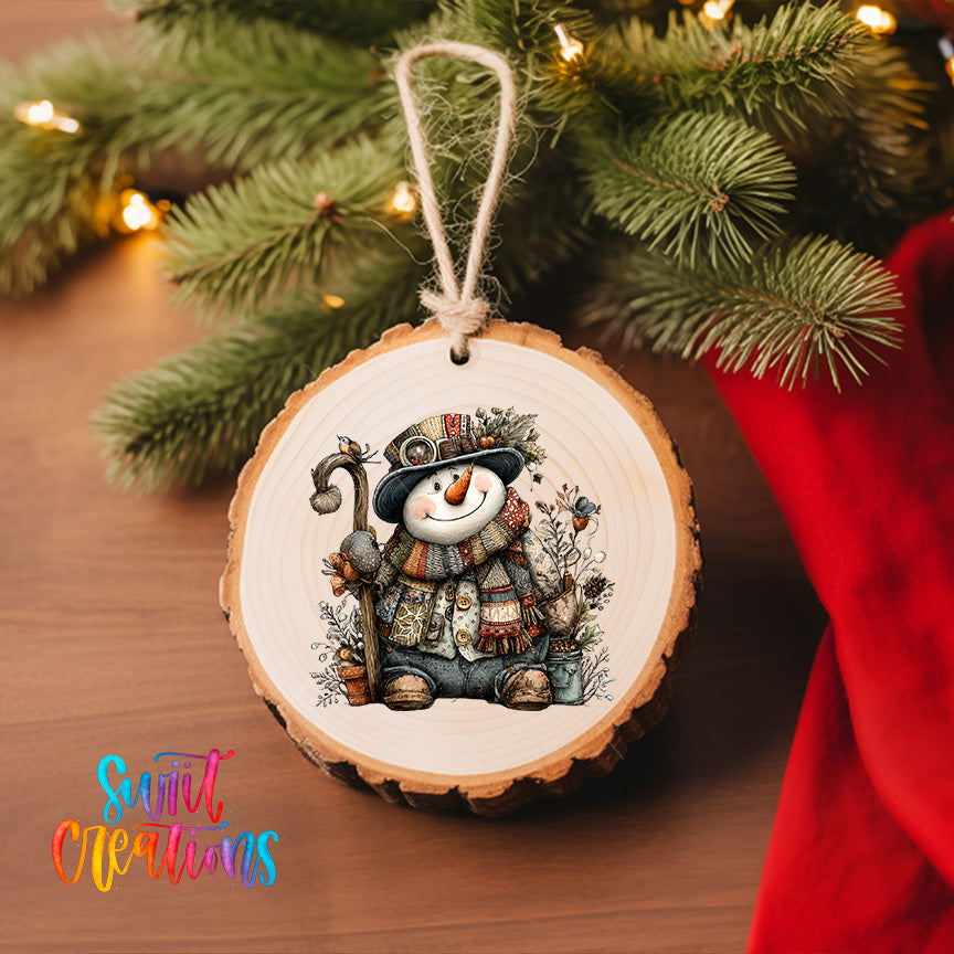 A wooden ornament featuring a smiling snowman is hanging on a Christmas tree, surrounded by pine branches and twinkling lights.