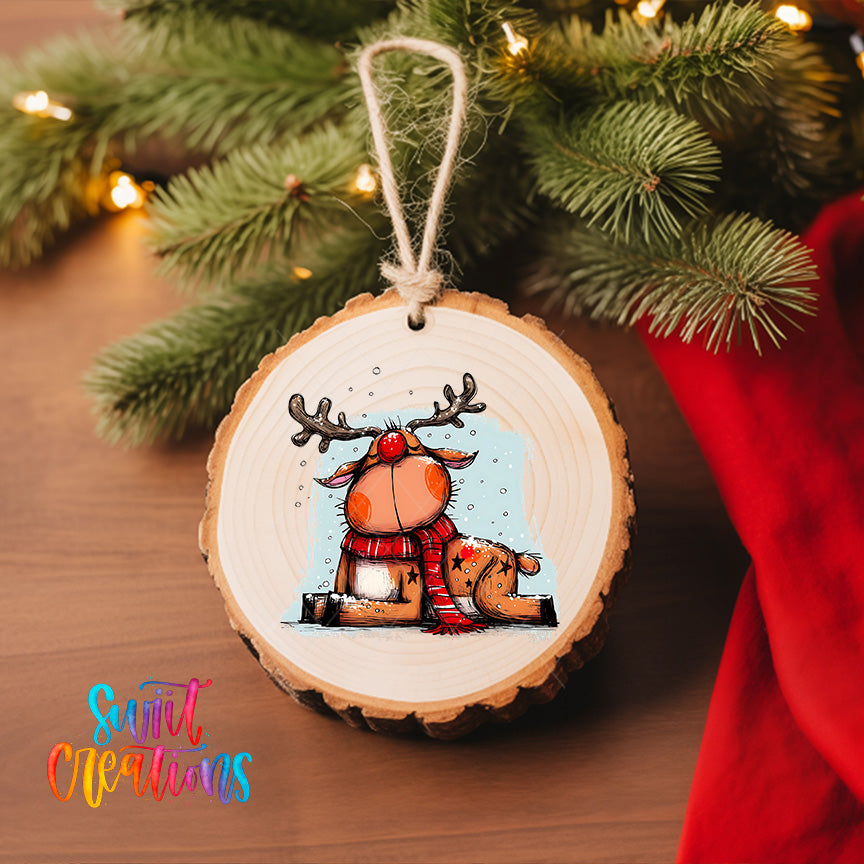 A wooden ornament featuring a cartoon reindeer with antlers and a scarf, hanging on a Christmas tree.