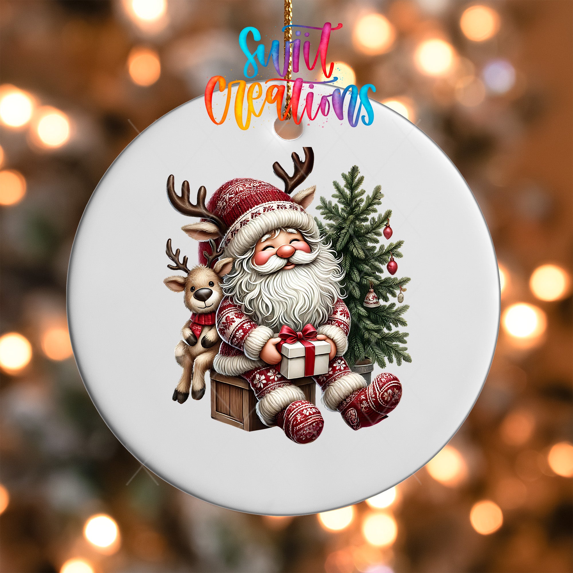 A white ornament featuring a smiling Santa Claus sitting on a wooden crate, with a reindeer and a Christmas tree nearby.