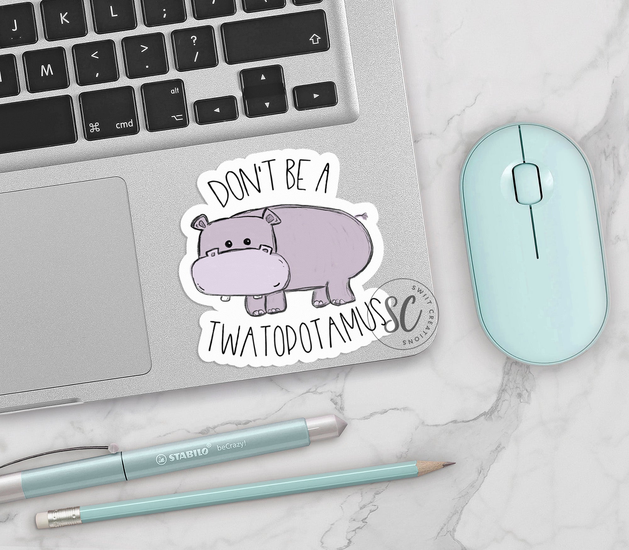 a laptop with a sticker of a hippo on it