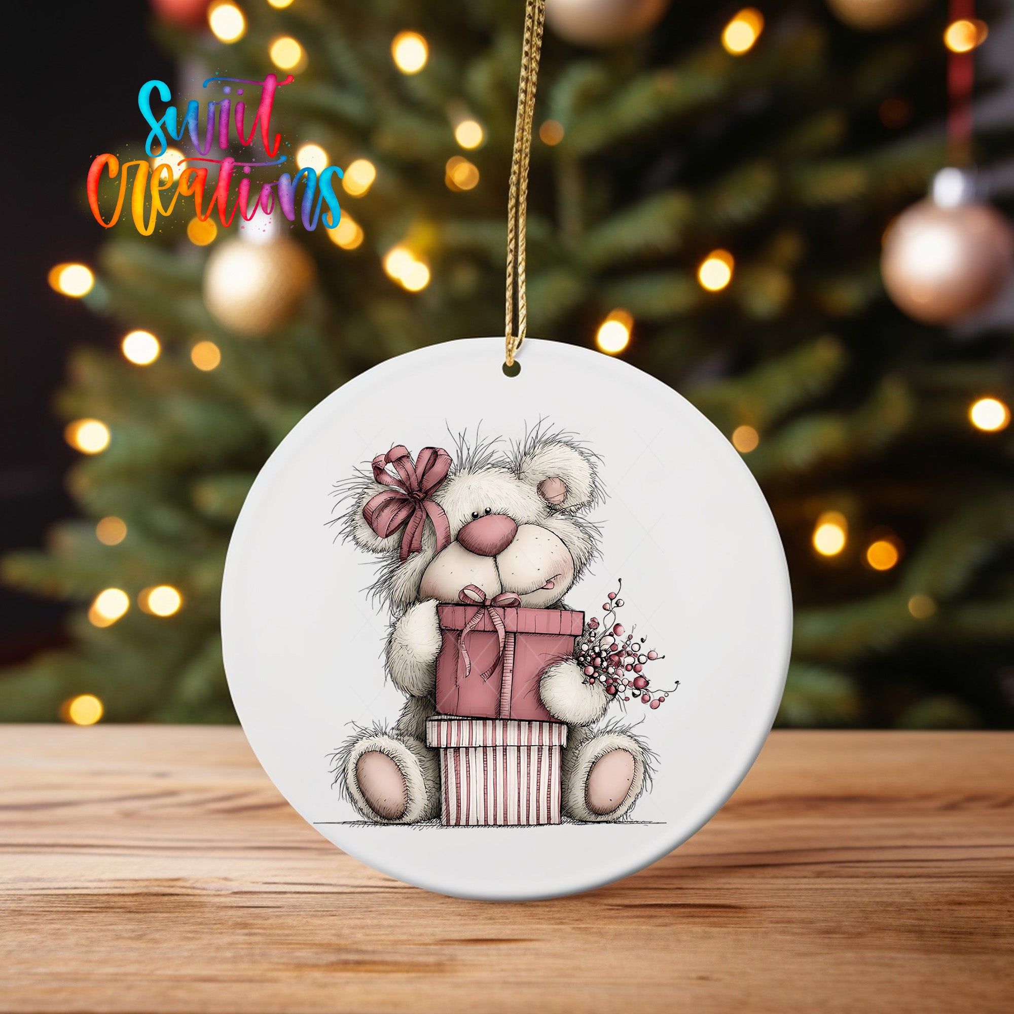 A white ceramic ornament featuring a teddy bear holding a gift box and flowers, with a Christmas tree in the background.