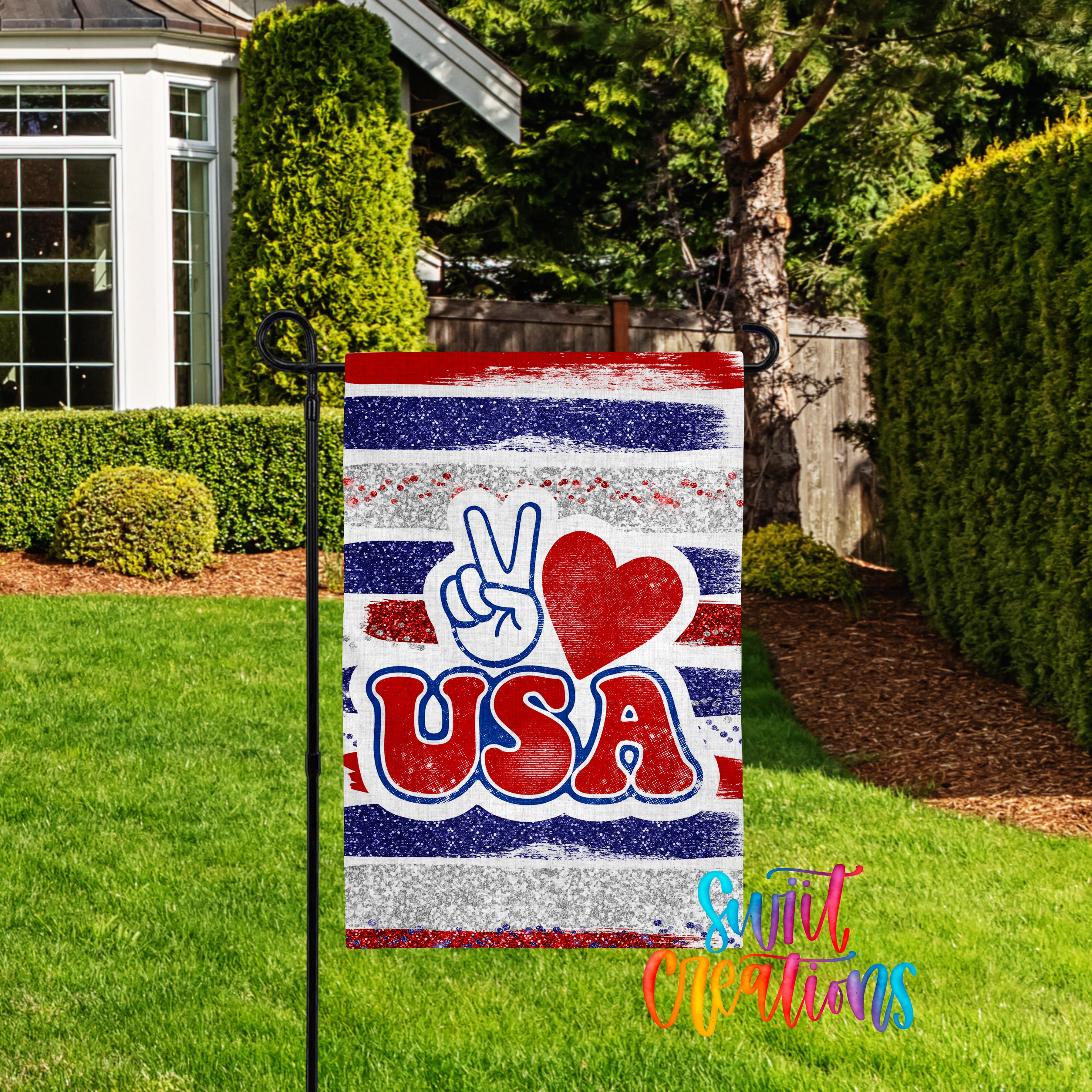 A patriotic flag with the word "USA" and a peace sign is displayed in a grassy yard, with a house and trees in the background.
