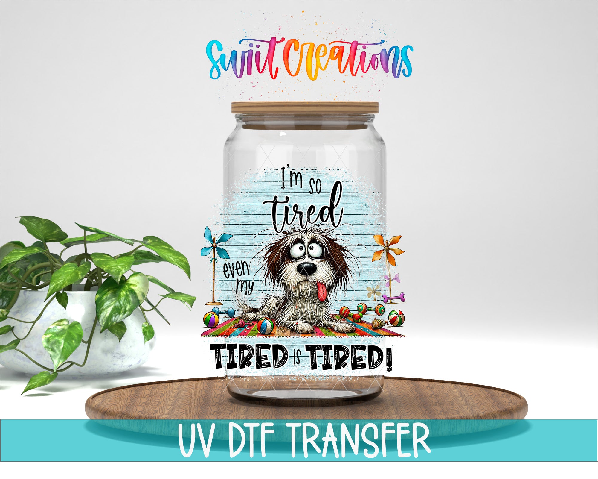 A glass jar with a cartoon dog on it, along with the text "I'm so tired even my dog is tired!" and "TIRED IS TIRED!" The jar is placed on a wooden surface, and there is a potted plant in the background.