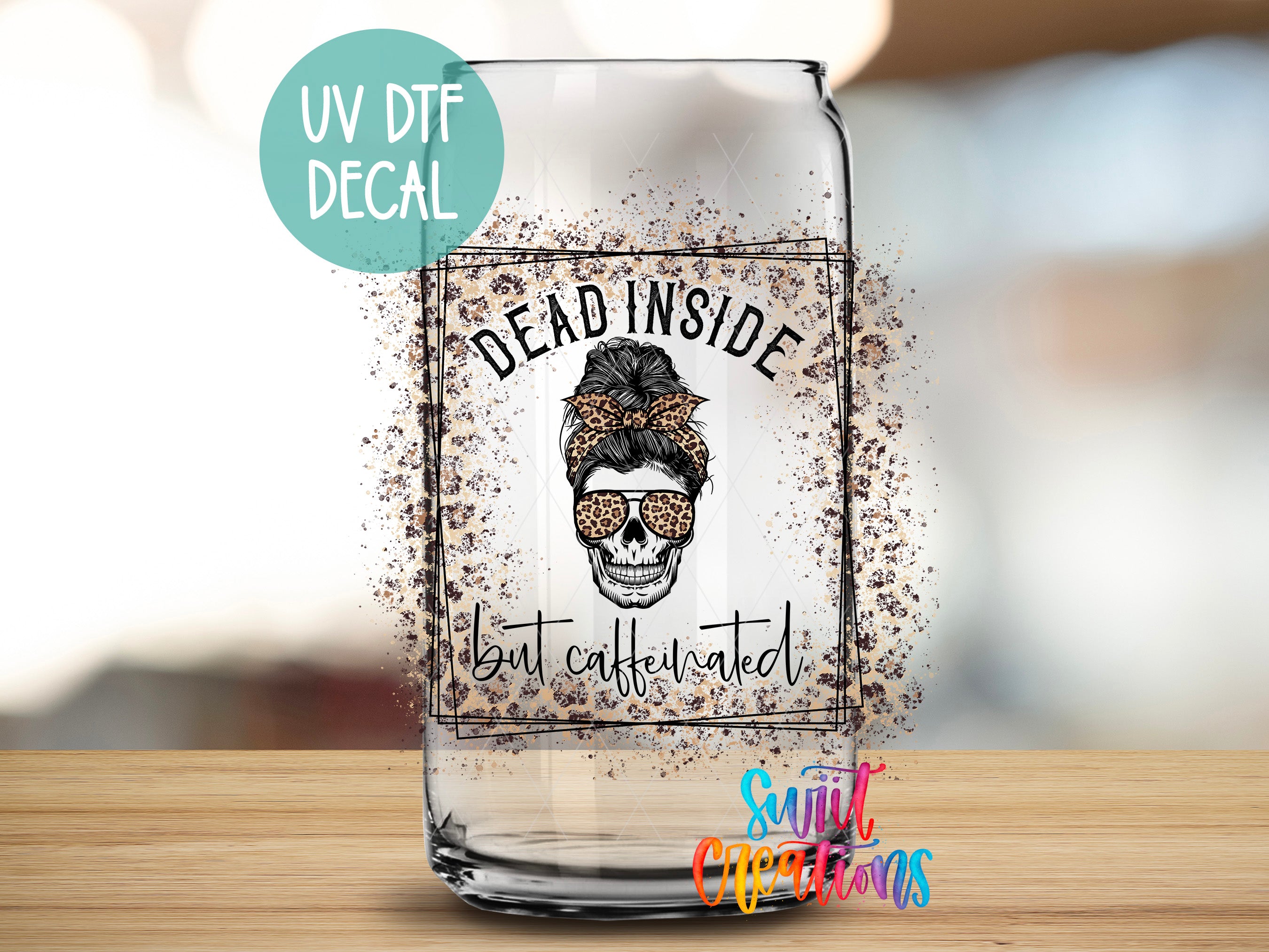 A glass with a skull design and the text "Dead inside but caffeinated" printed on it, along with a UV decal and a watermark.