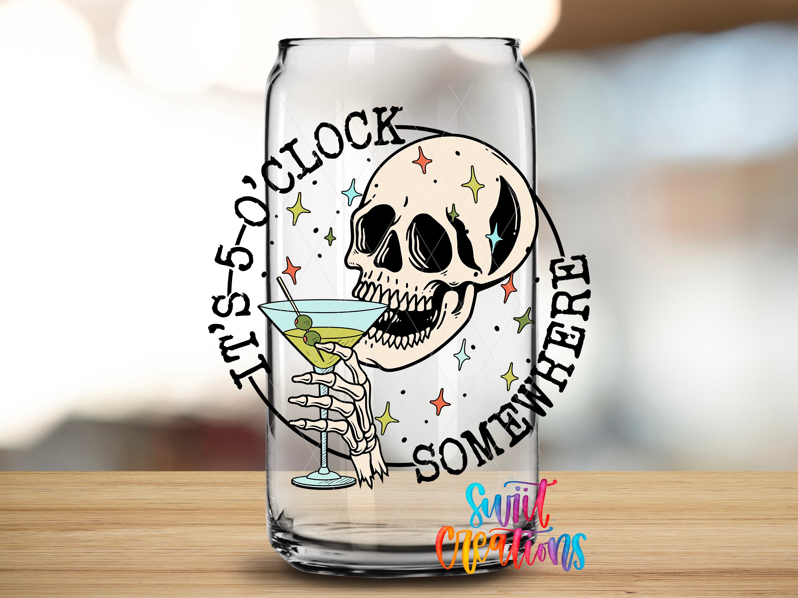 A glass with a skull and a cocktail glass, along with the text "It's 5 o'clock somewhere" and "SOMEWHERE" written around the image.