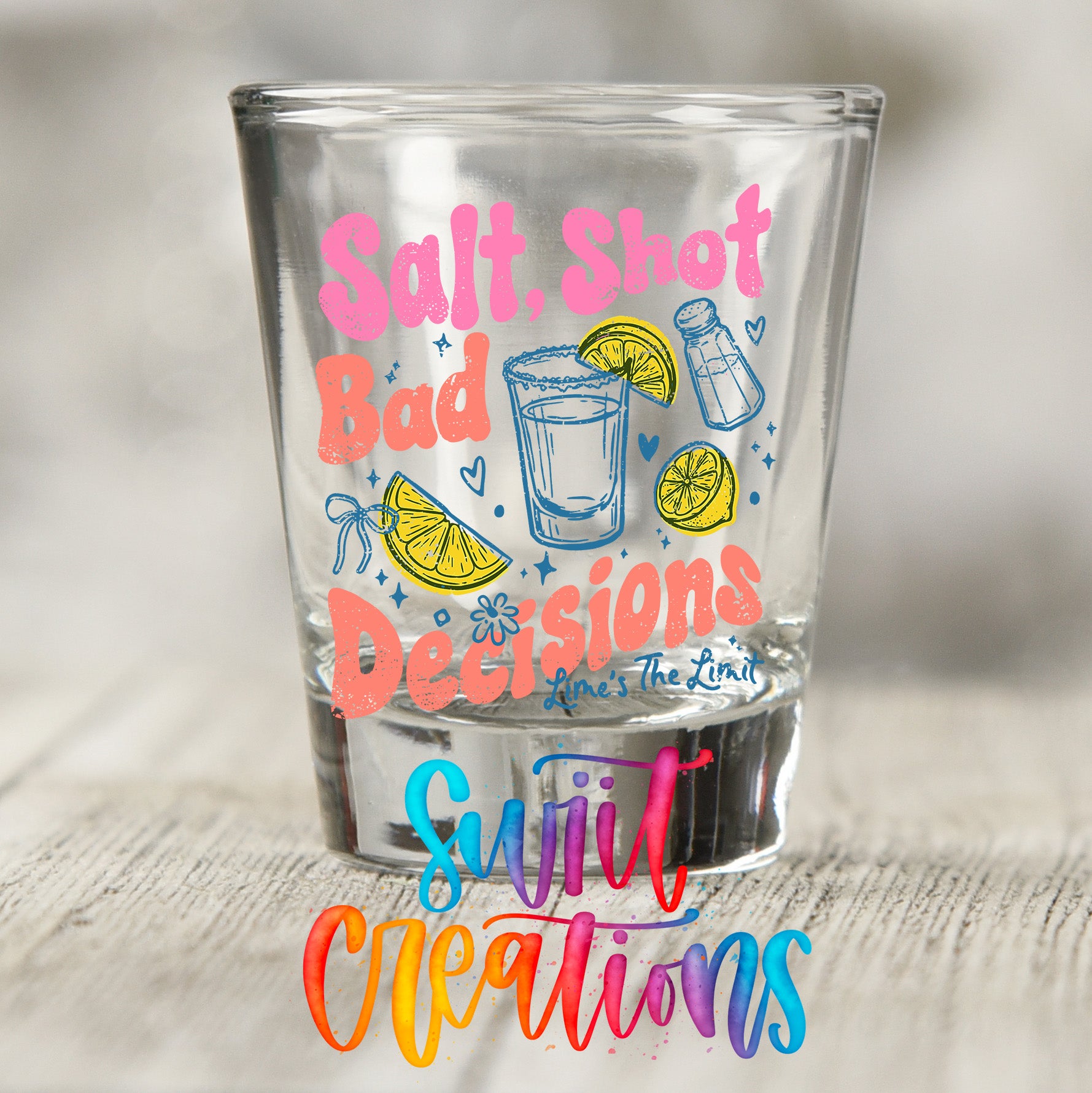A shot glass with a colorful design featuring text and illustrations related to salt, shot, bad decisions, and the limit.