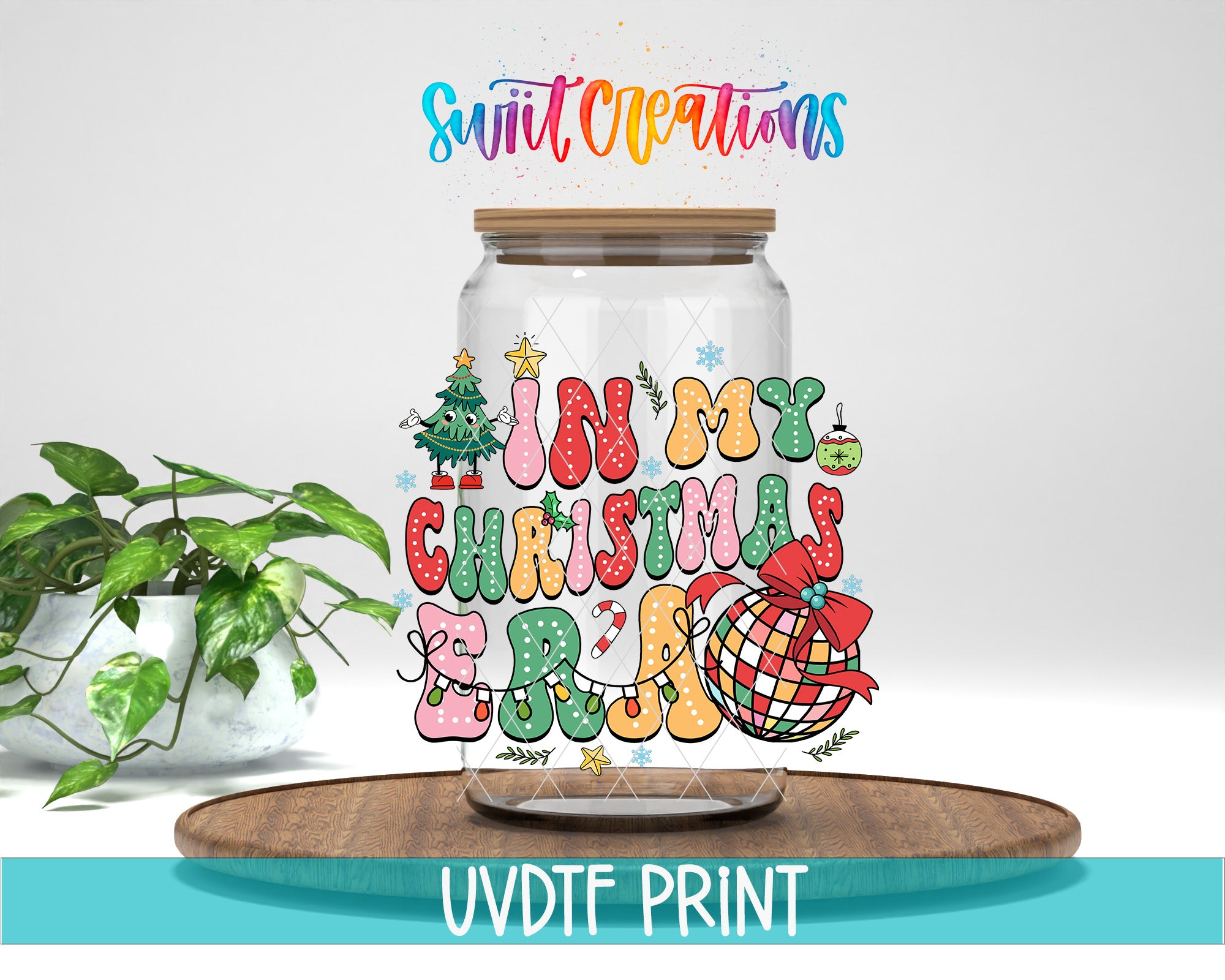 A glass jar with a colorful, festive design featuring Christmas-themed elements such as a Christmas tree, ornaments, and a bow. The jar is placed on a wooden surface, and there is a potted plant in the background.