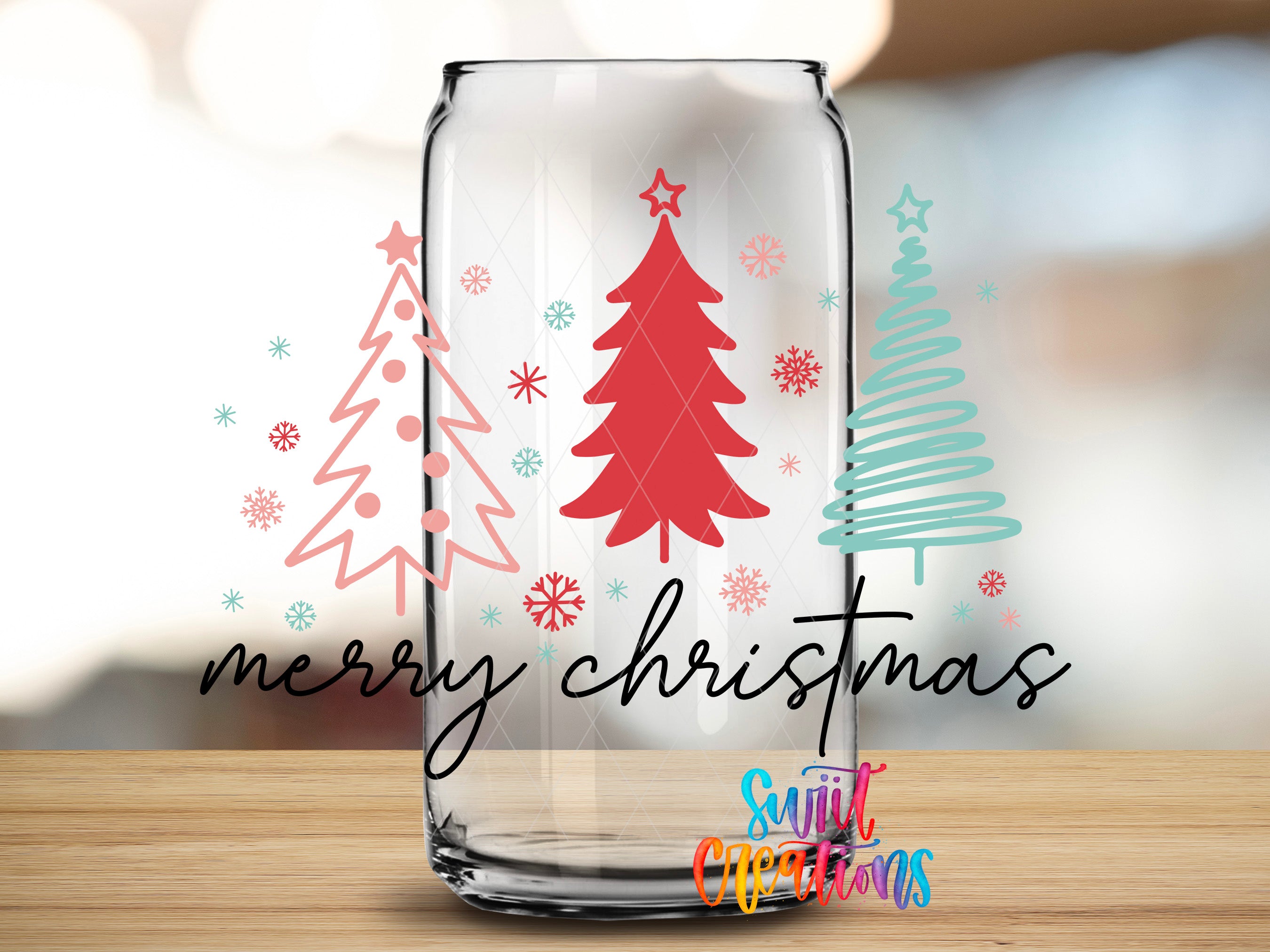 A glass can with a festive Christmas tree design and snowflakes on it, along with the text "merry christmas" and "Suitcase Creations" written on it.