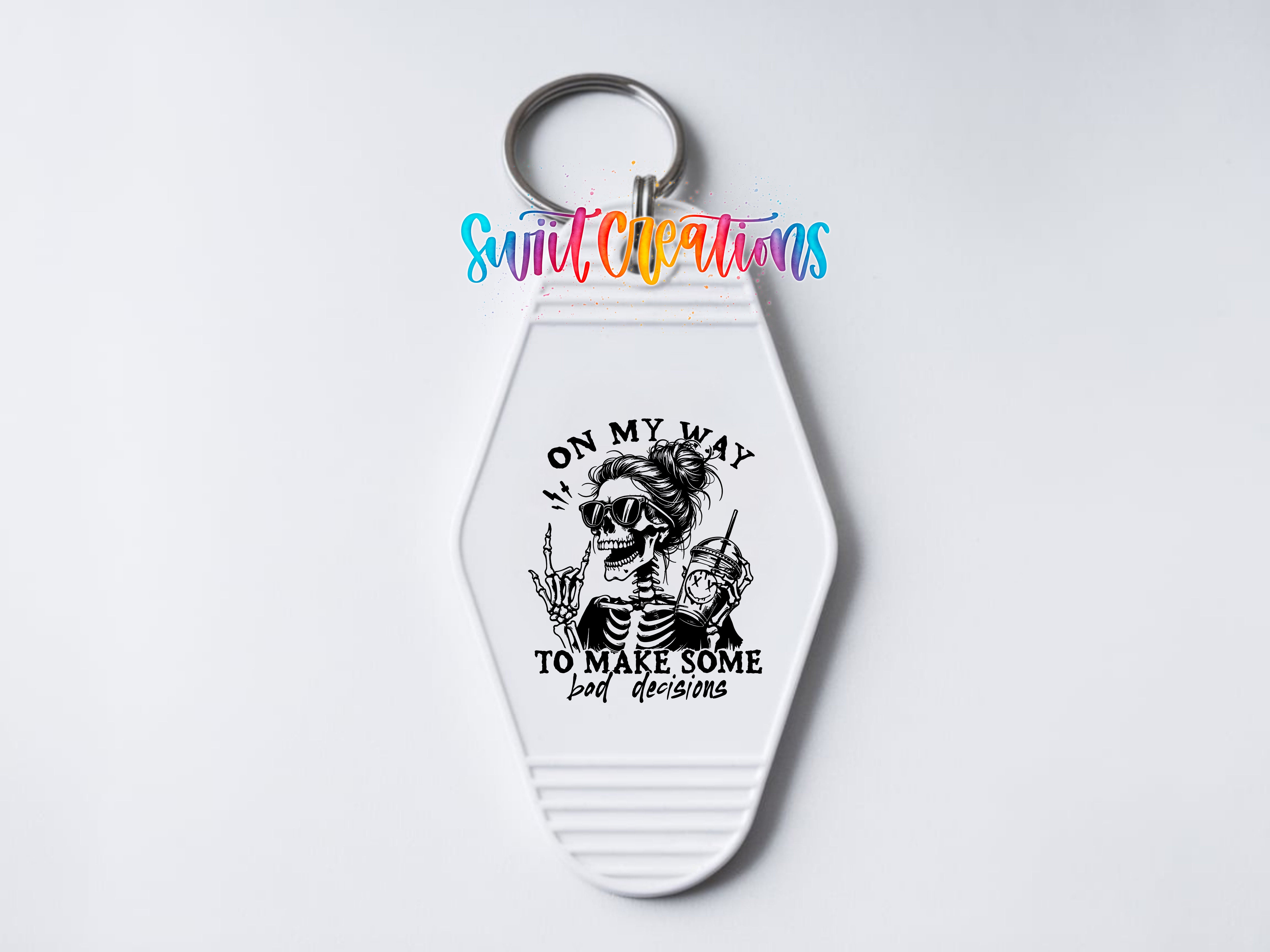 A keychain with a skeleton design and the text "ON MY WAY TO MAKE SOME BAD DECISIONS" printed on it.