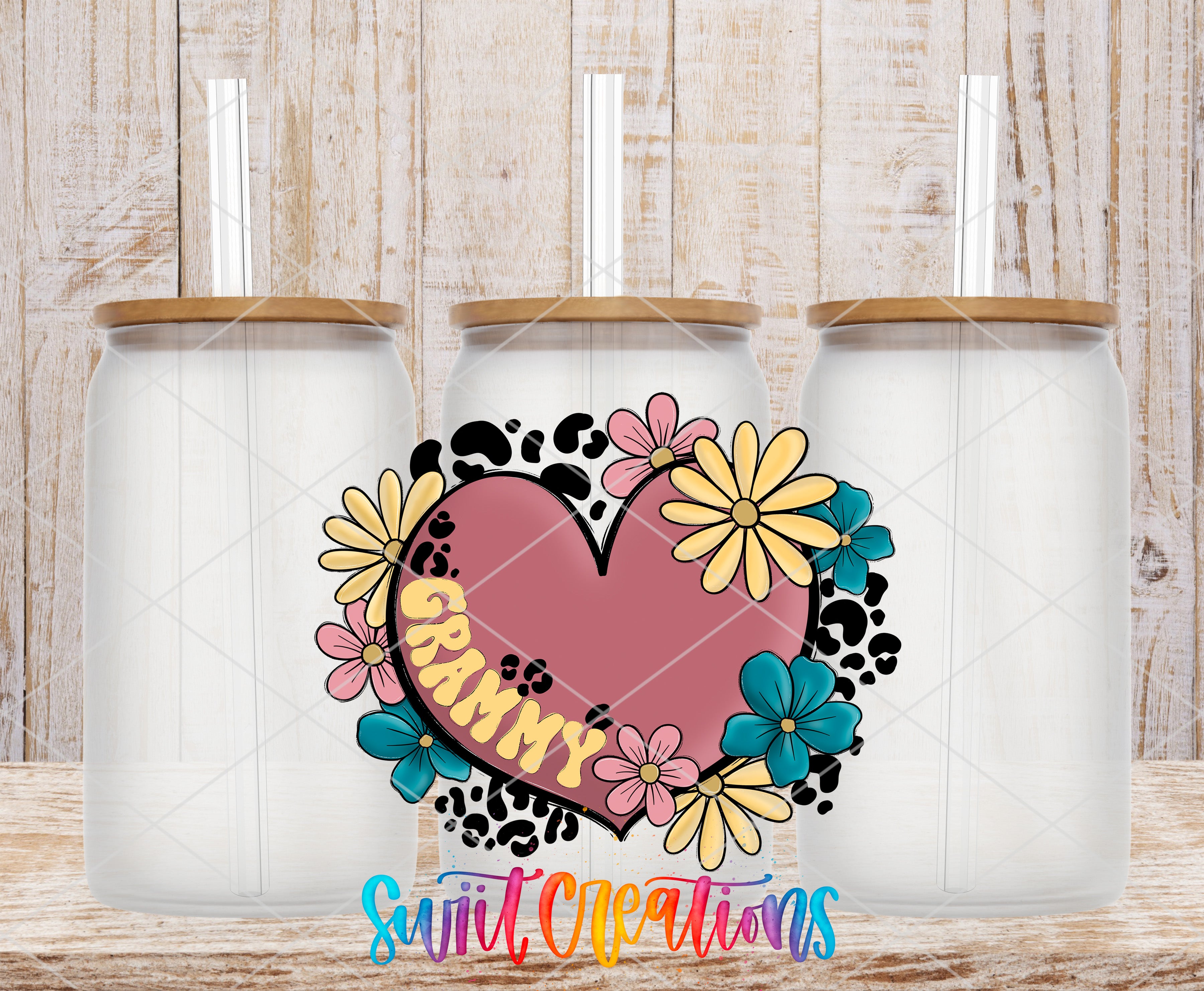 three glass jars with lids, each containing a straw, arranged in a row against a wooden background. The jars are decorated with a colorful floral design, including a heart-shaped element with the word "GRAMMY" written on it.