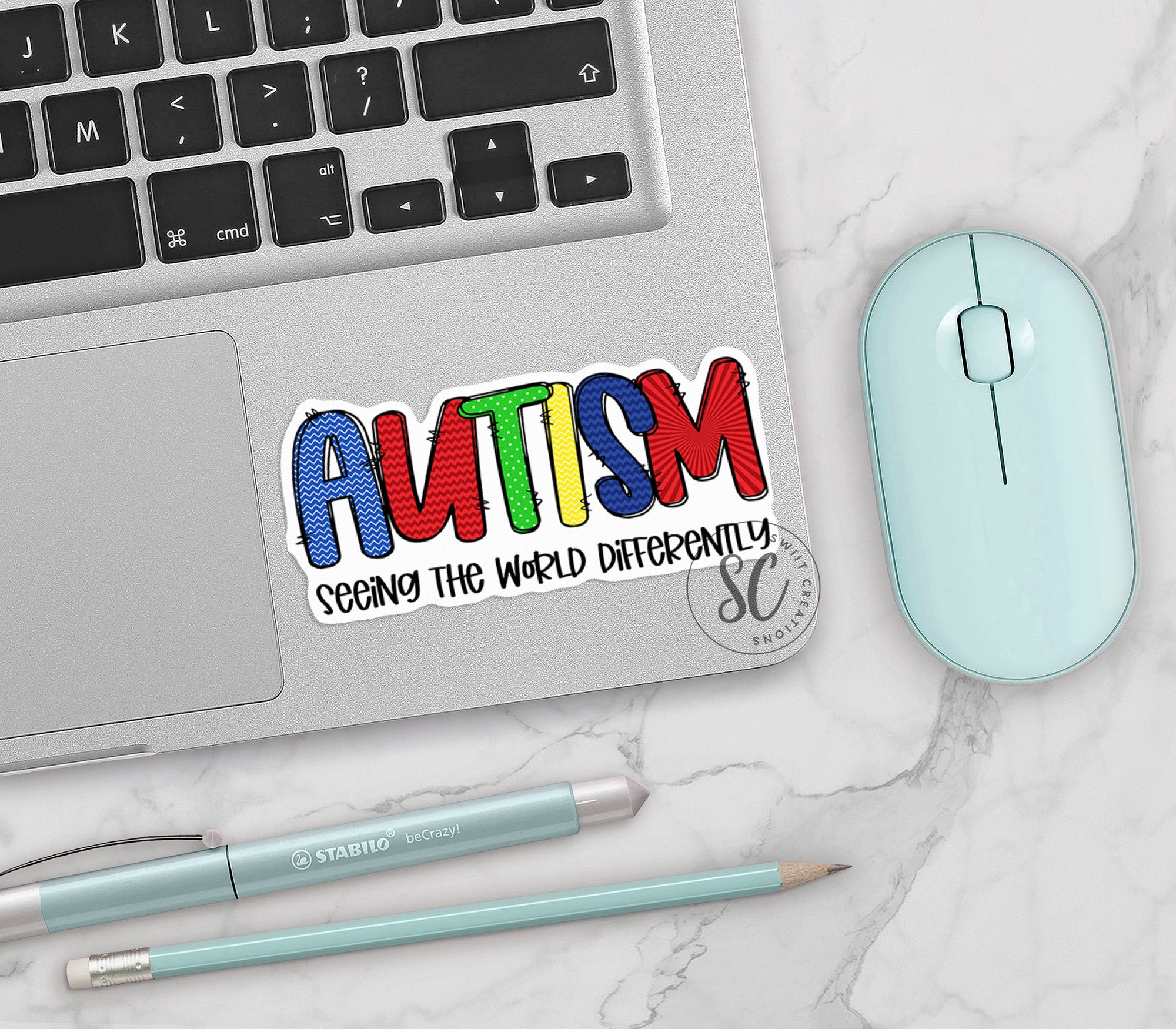 a laptop with a sticker on it next to a mouse