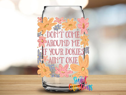 Dokies Ain’t Okie UV DTF transfer applied to a clear glass can from Swiit Creations