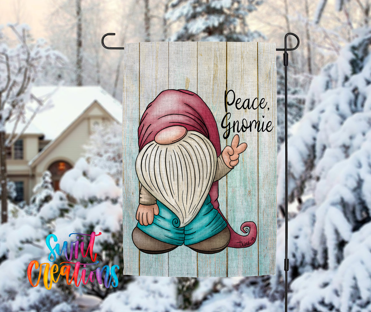 A garden gnome with a peace sign is displayed on a wooden sign, with a snowy winter landscape in the background.