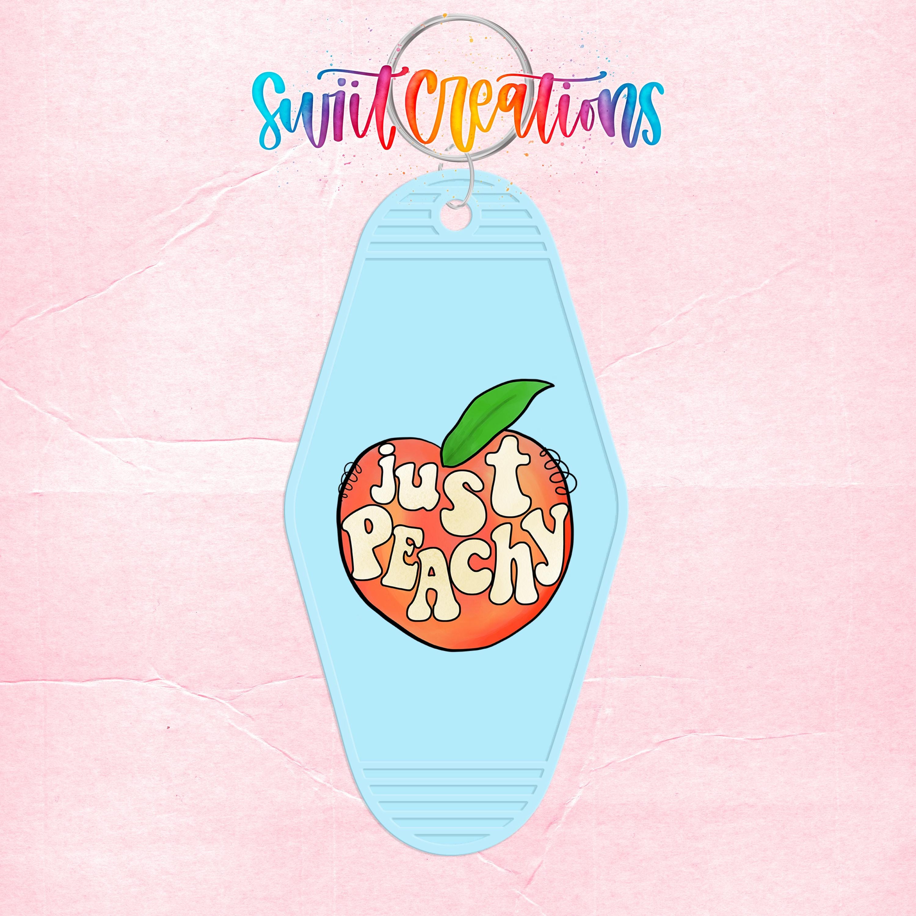 A keychain with a light blue oval shape and a graphic of an orange peach with the text "Just Peachy" written on it.