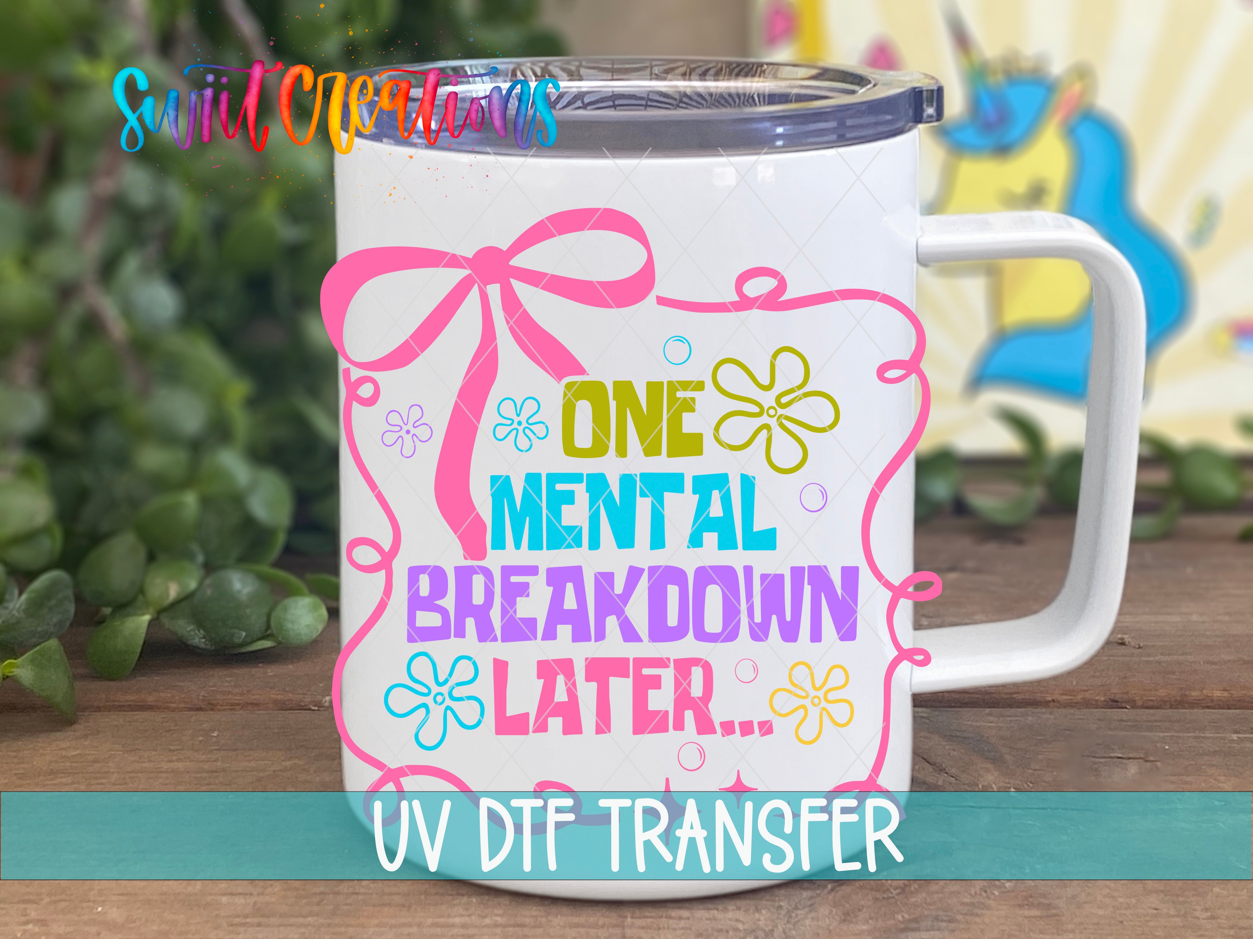 A white mug with a colorful graphic design and text on it, placed on a wooden surface.