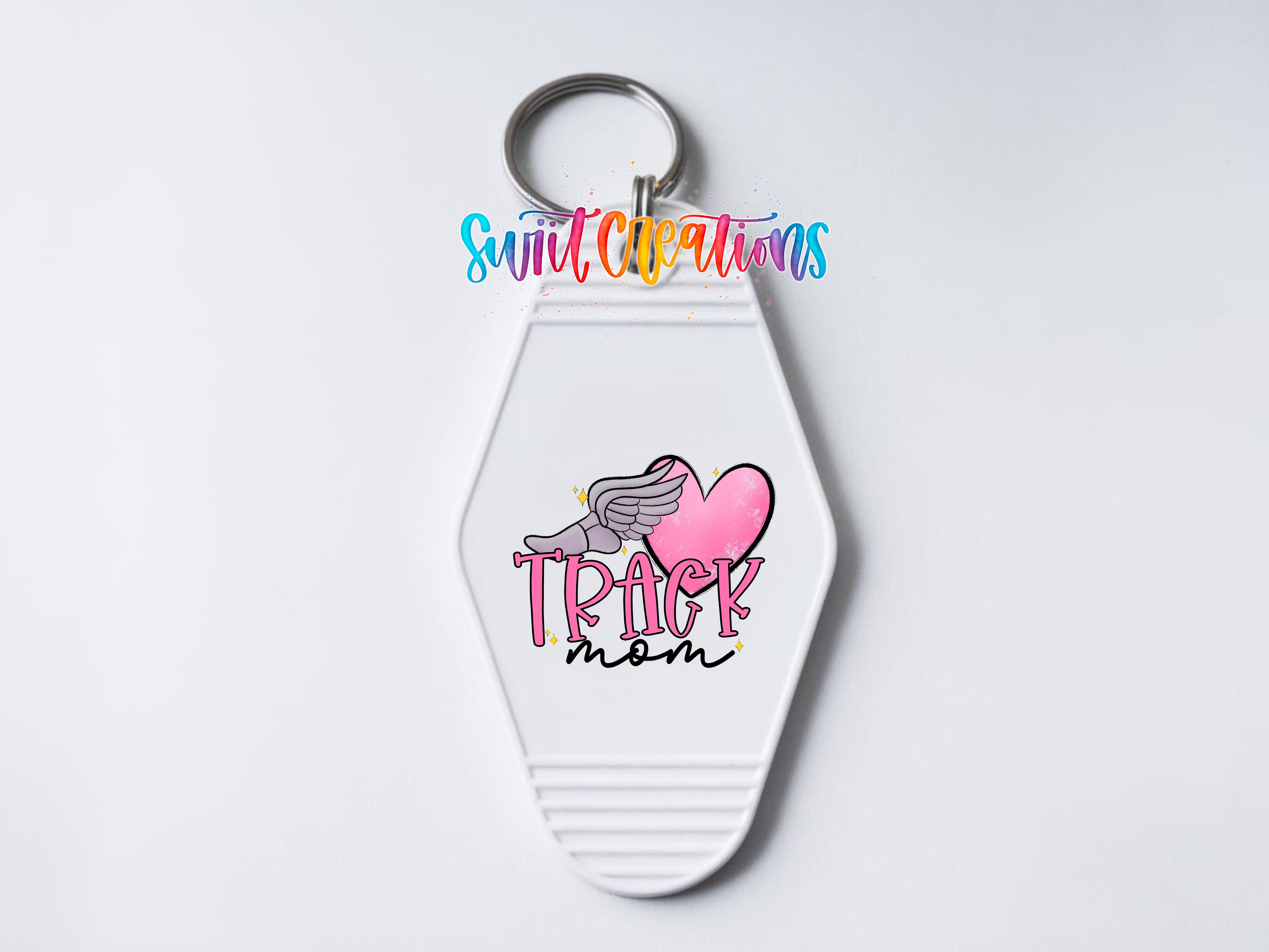 A keychain with a white hexagonal shape and a heart-shaped graphic on it. The keychain has a keyring attached to it.