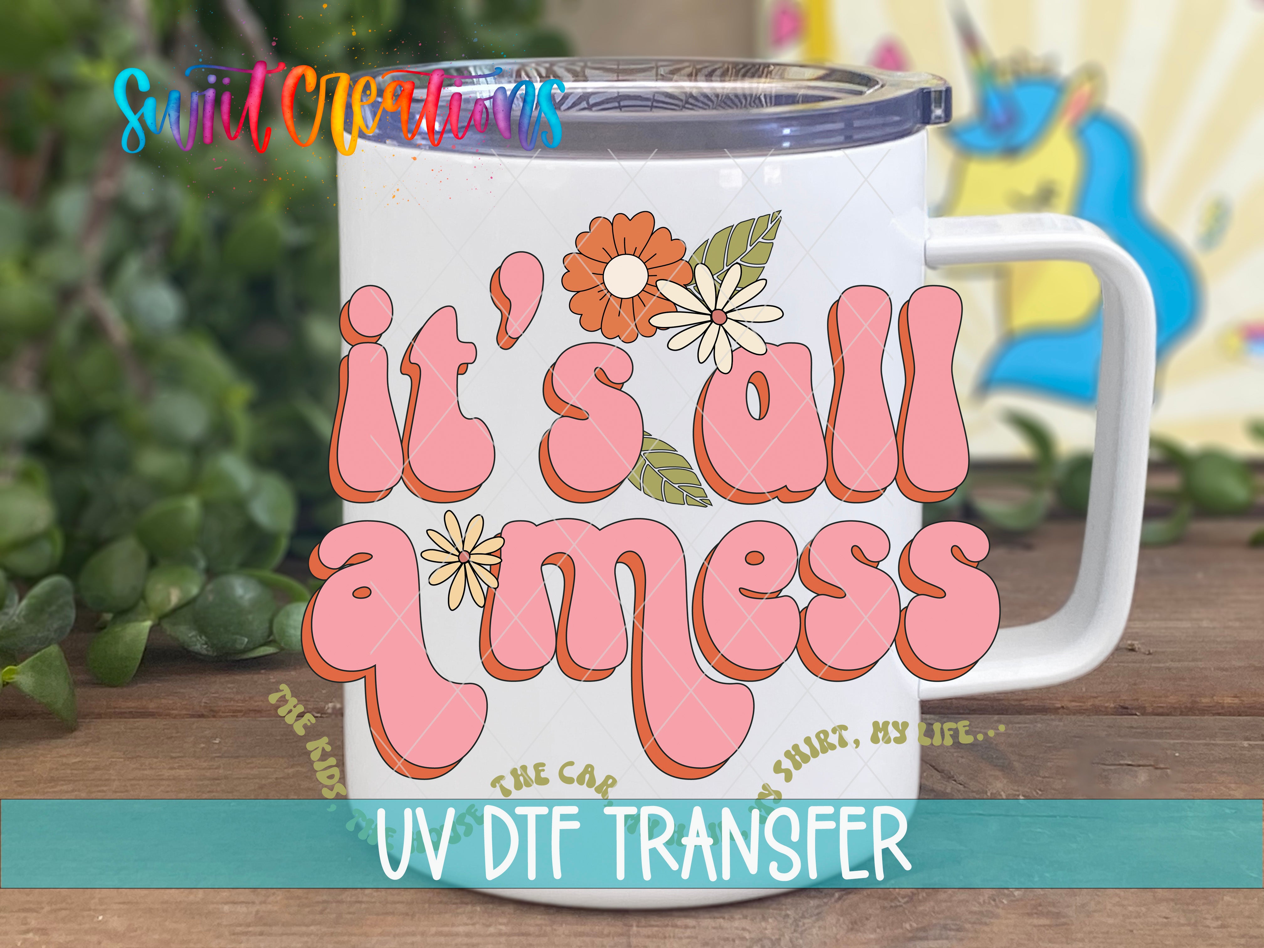 A white mug with colorful text and floral designs on it, placed on a wooden surface.