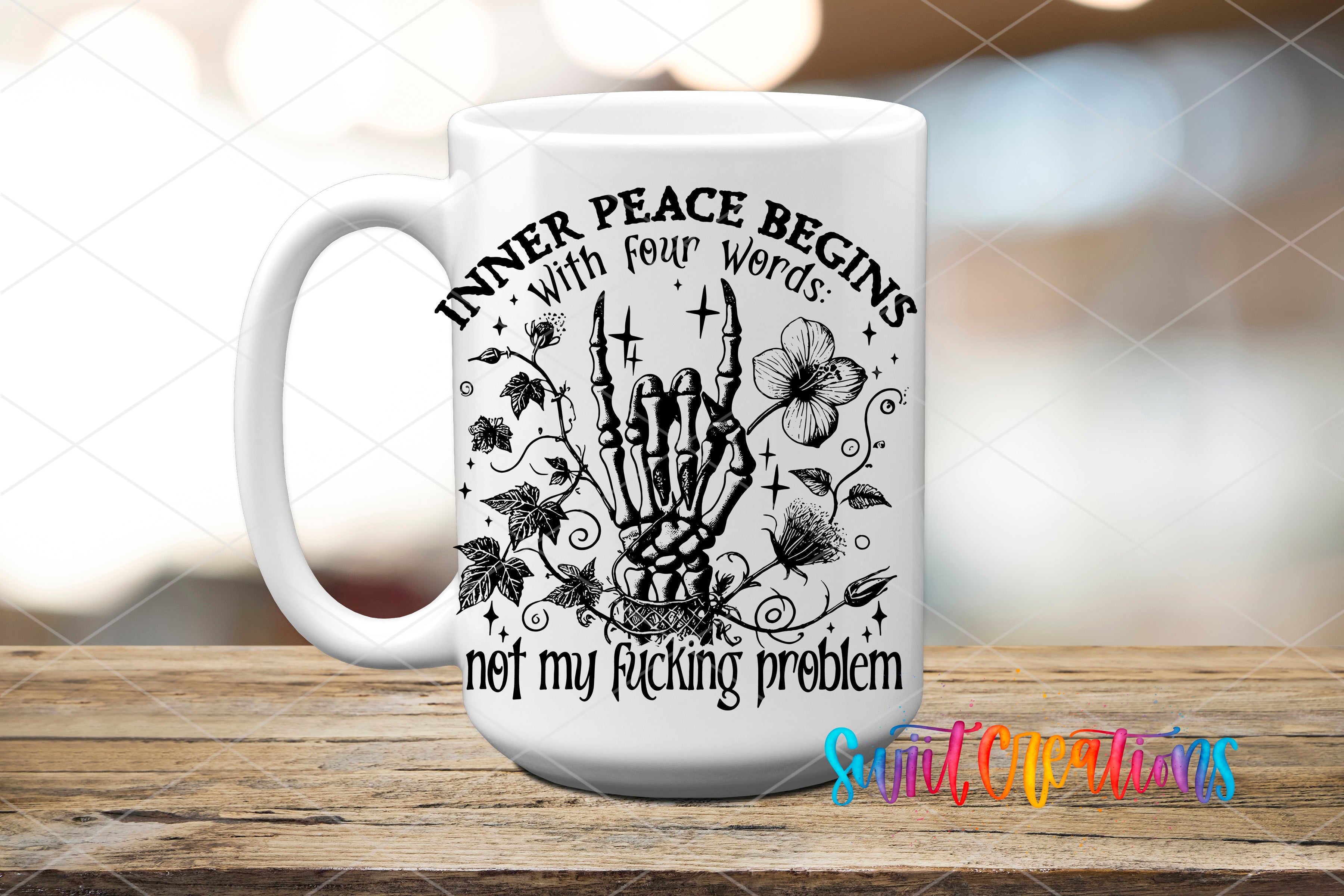 A white ceramic mug with a black and white graphic design featuring a skeleton hand holding a flower, surrounded by leaves and twigs. The text on the mug reads "INNER PEACE BEGINS with four words: not my fucking problem".