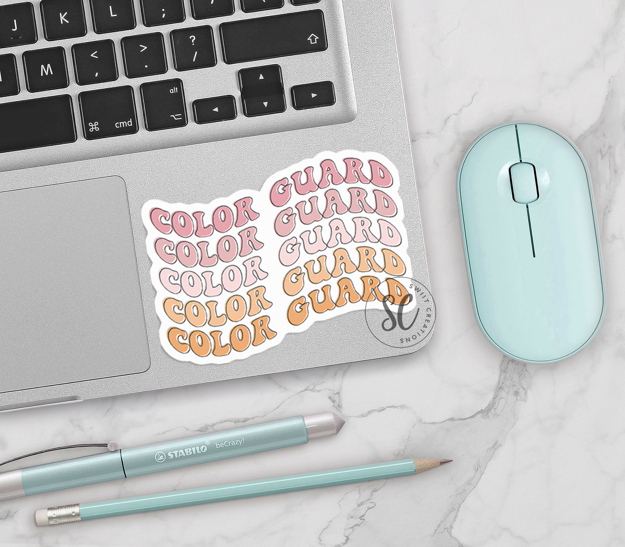 a computer keyboard, mouse, and sticker on a table