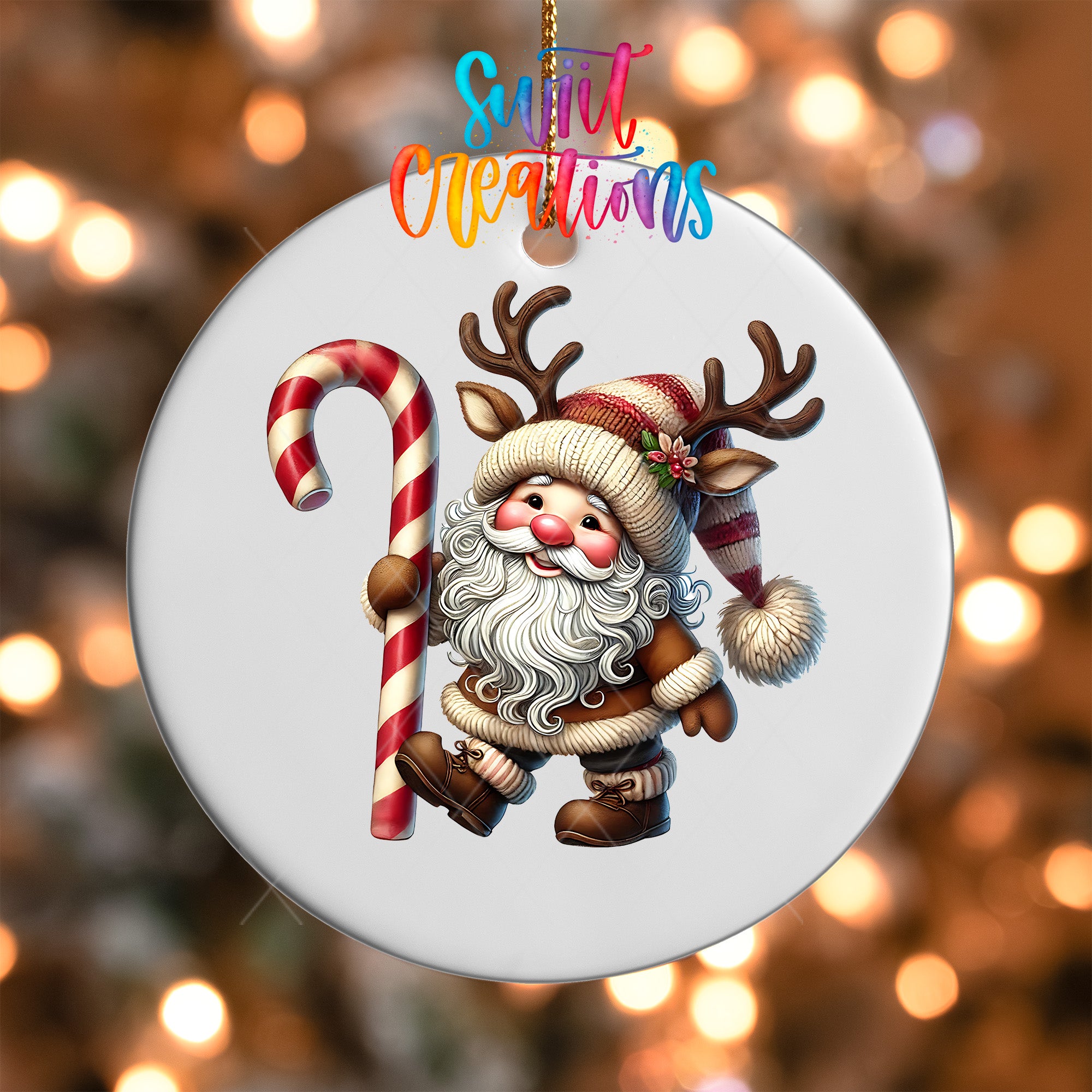 A white ornament with a cartoon Santa Claus figure holding a candy cane and antlers, set against a blurred background with colorful lights.