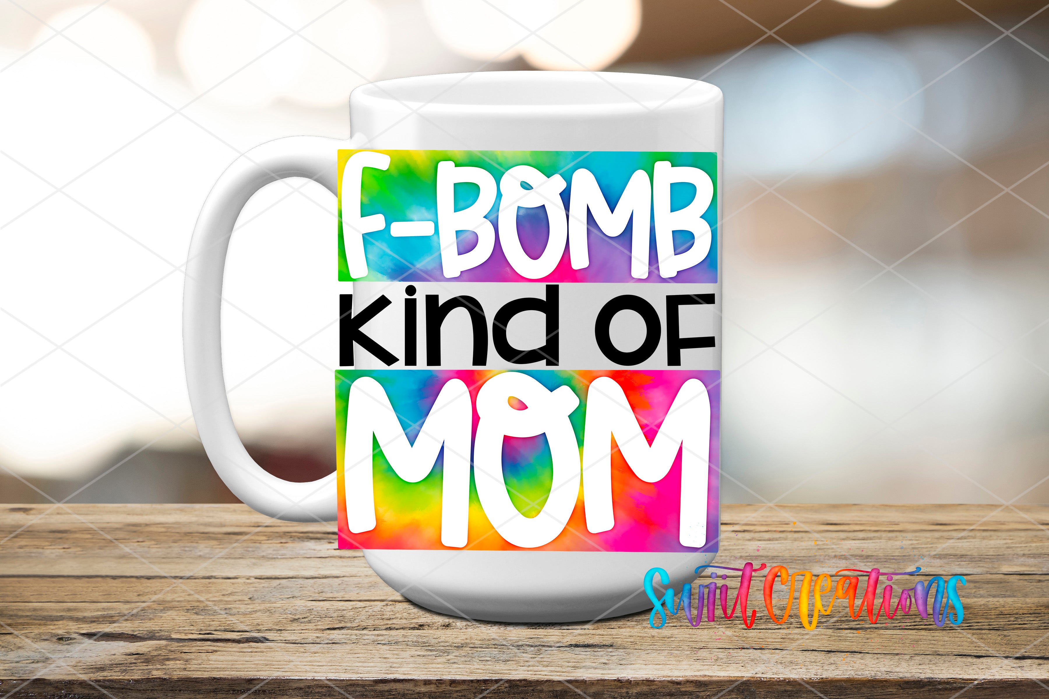 A white mug with a colorful design featuring the text "F-BOMB kind of MOM" in a tie-dye style.