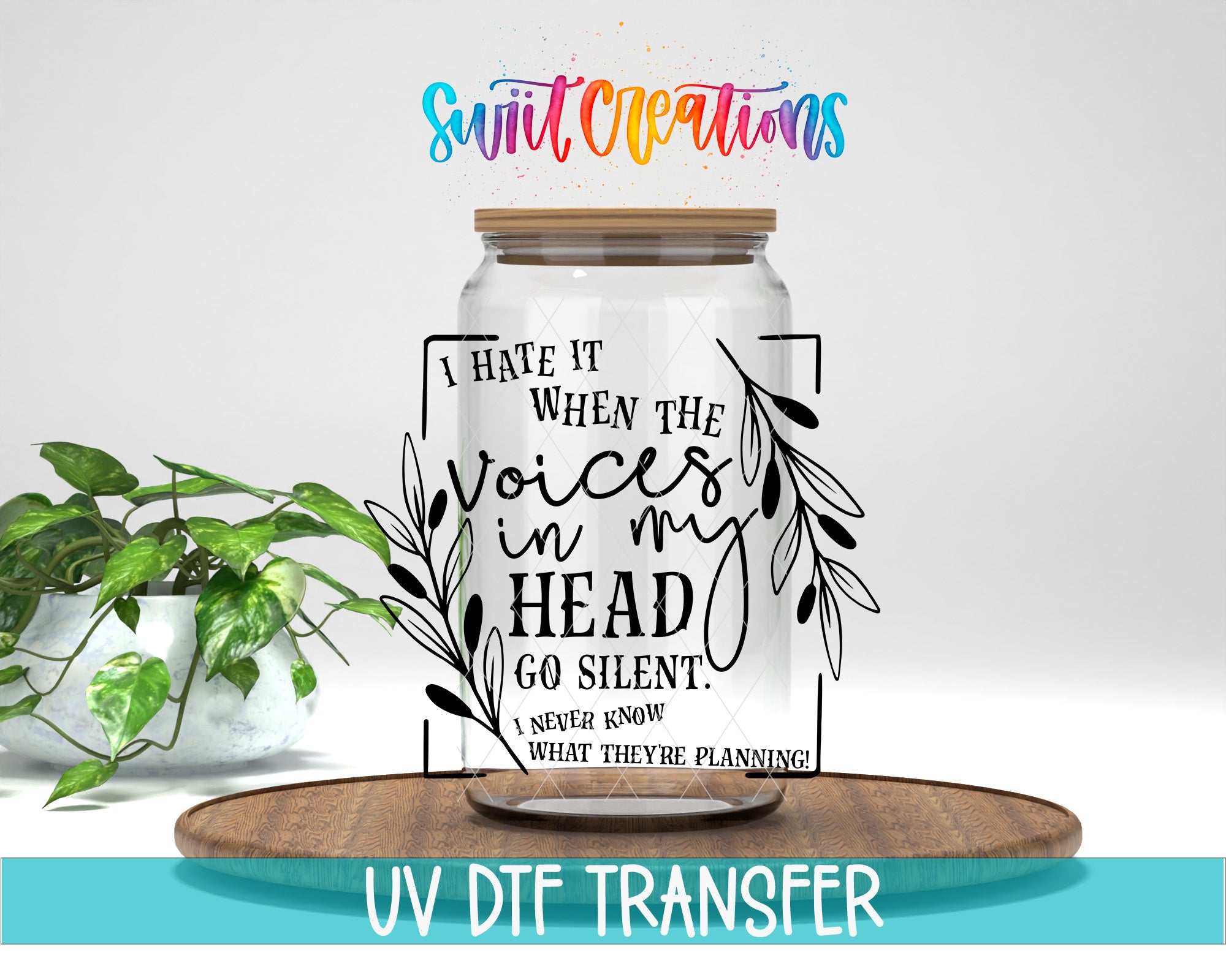 a clear glass jar with a wooden lid, placed on a wooden tray. The jar has a printed text on it that says "I hate it when the voices in my head go silent. I never know what they're planning." The text is surrounded by decorative leaves. The image also includes the text "UV DFT TRANSFER" at the bottom.