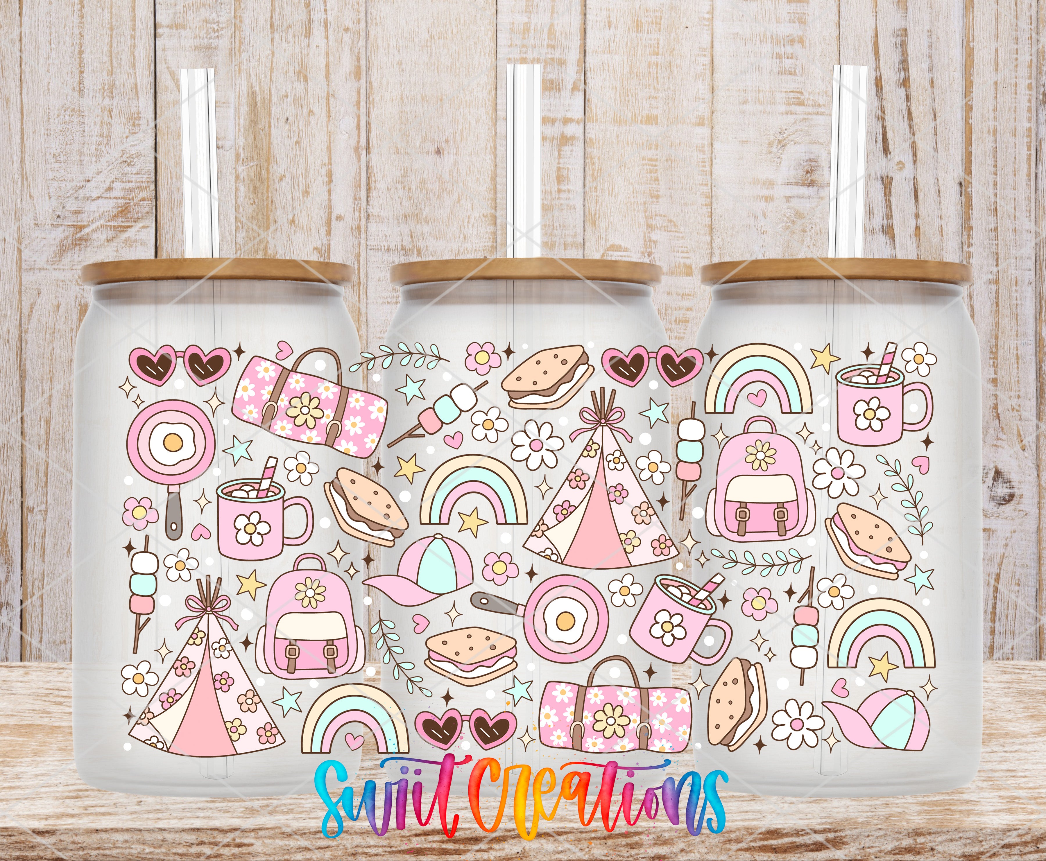 A collection of three glass jars with colorful designs and illustrations on them, placed on a wooden surface.