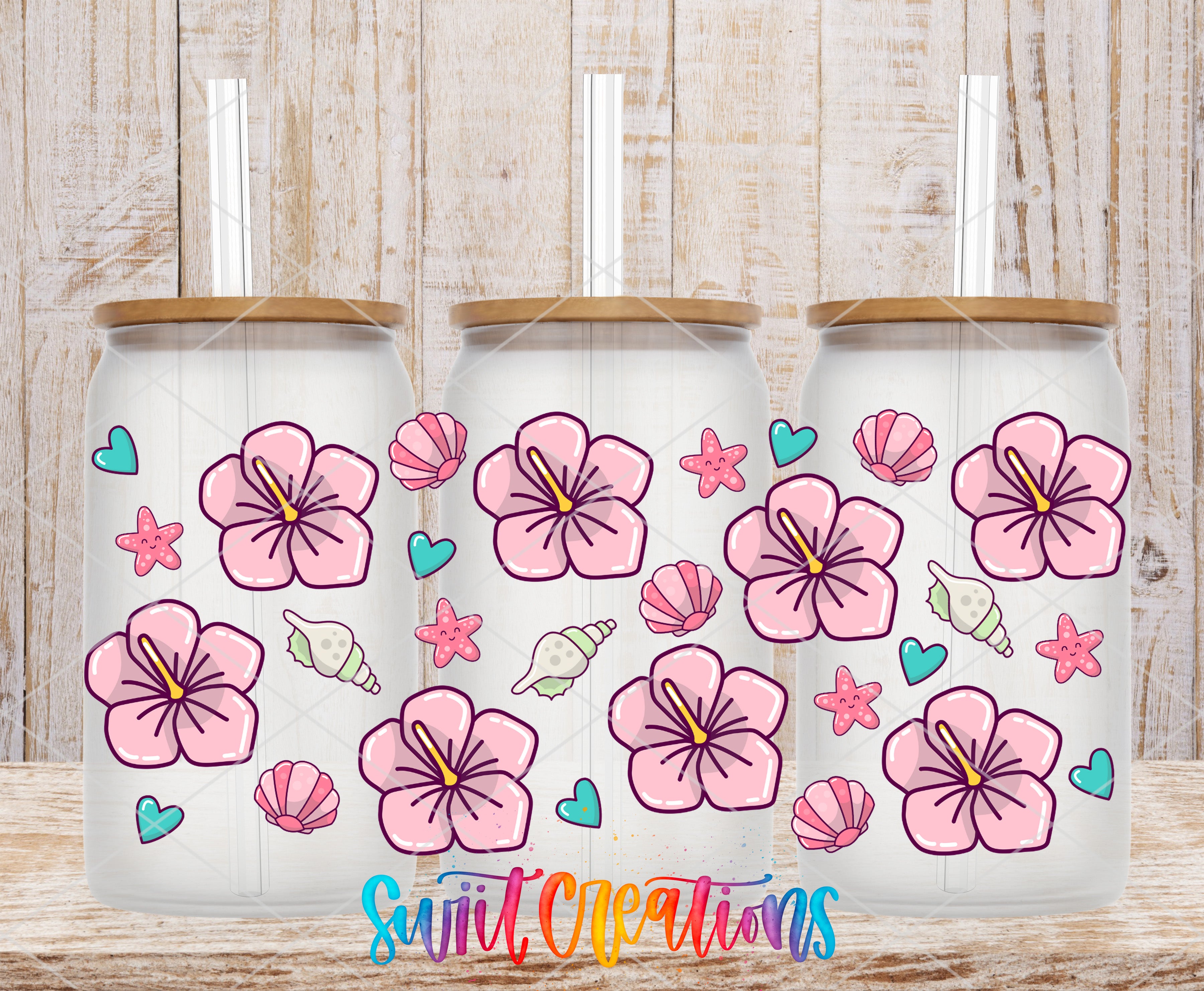 Three glass tumblers with a floral design and straws, placed on a wooden surface.