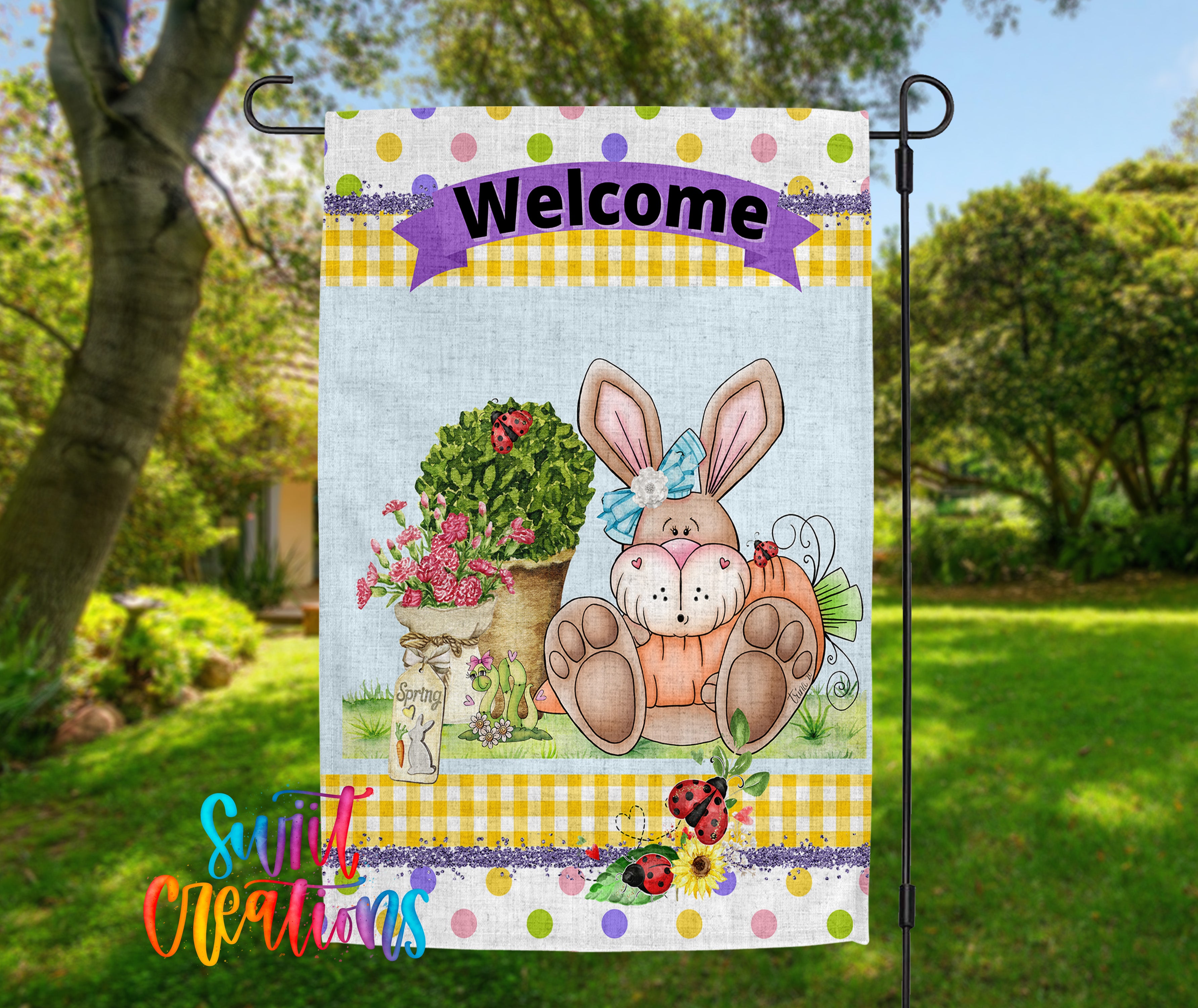 A colorful welcome sign featuring a cartoon rabbit sitting in a pot of flowers, with a banner that says "Welcome" above it. The sign is displayed outdoors in a garden setting.