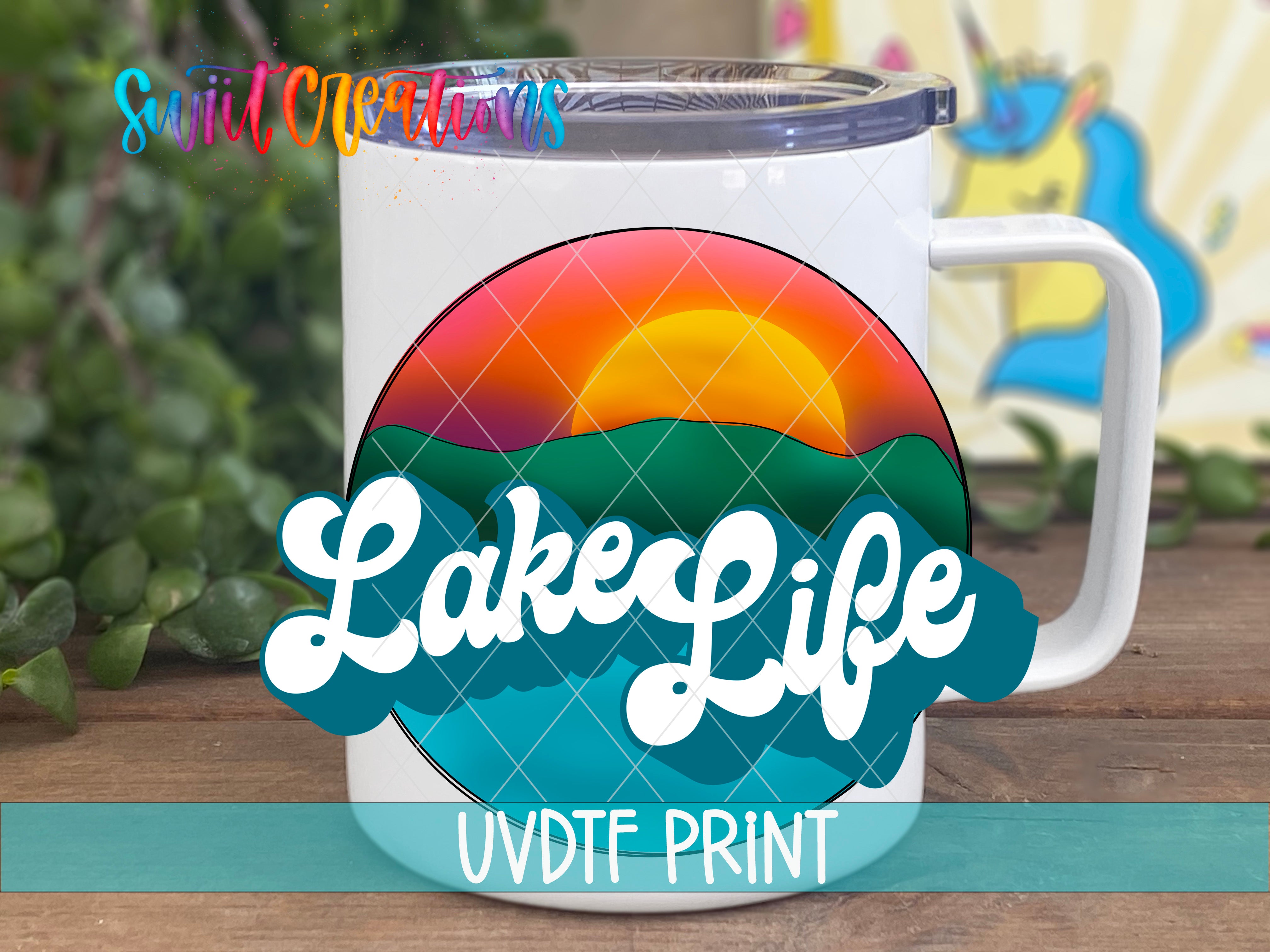 A white mug with a colorful graphic design featuring a sunset and mountains, along with the text "LakeLife" and "UVDF PRINT" printed on it.