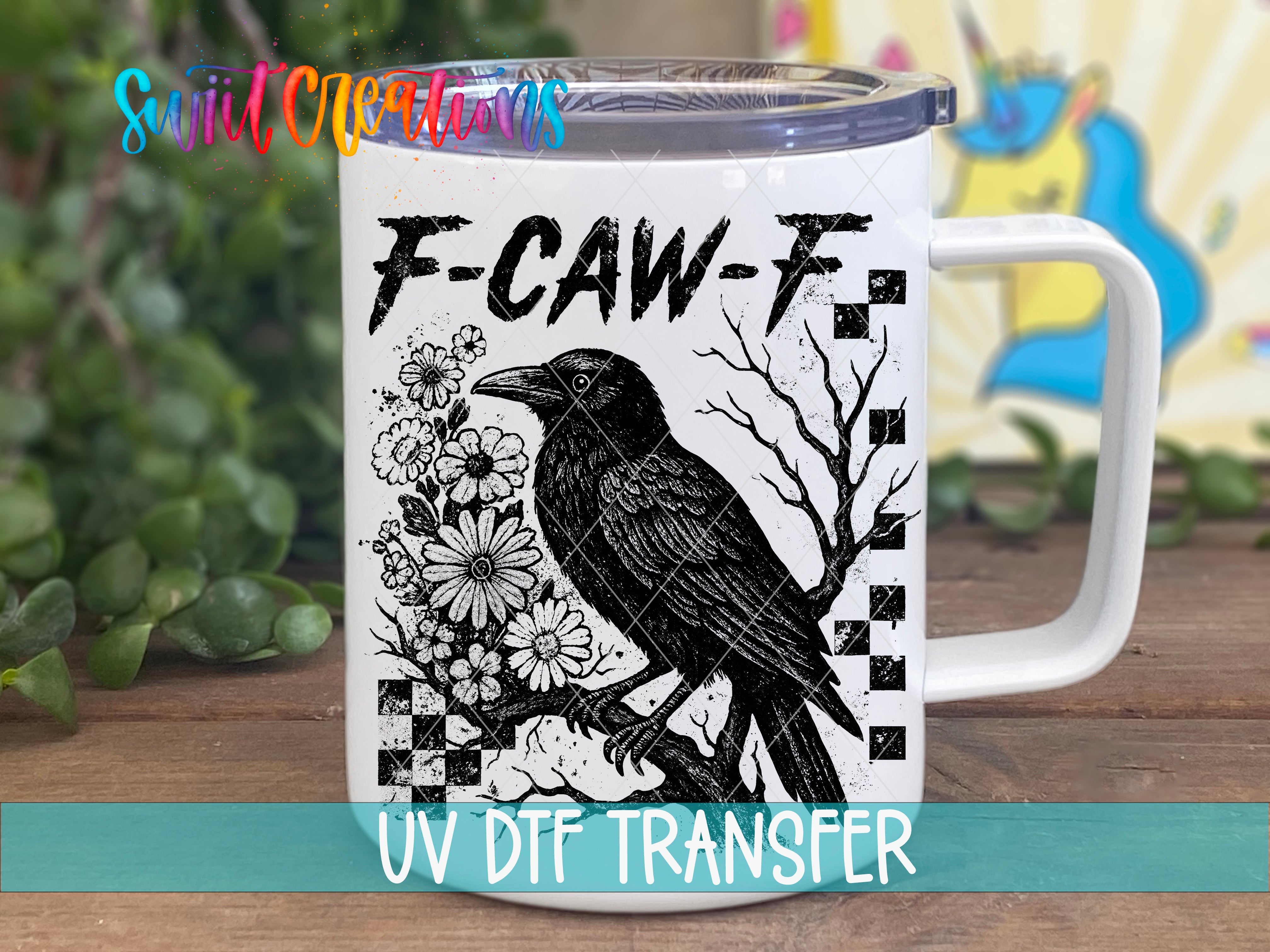 A white mug with a black and white illustration of a bird, along with the text "F-CAW-F" and "UV Dtf Transfer" printed on it.