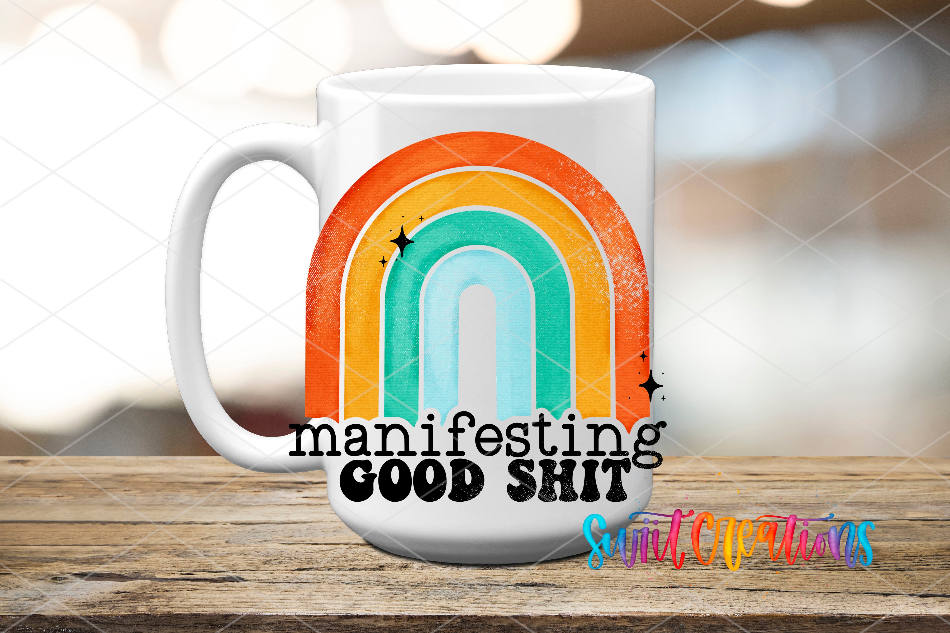 A white mug with a colorful rainbow design and the text "manifesting good shit" printed on it, placed on a wooden surface.