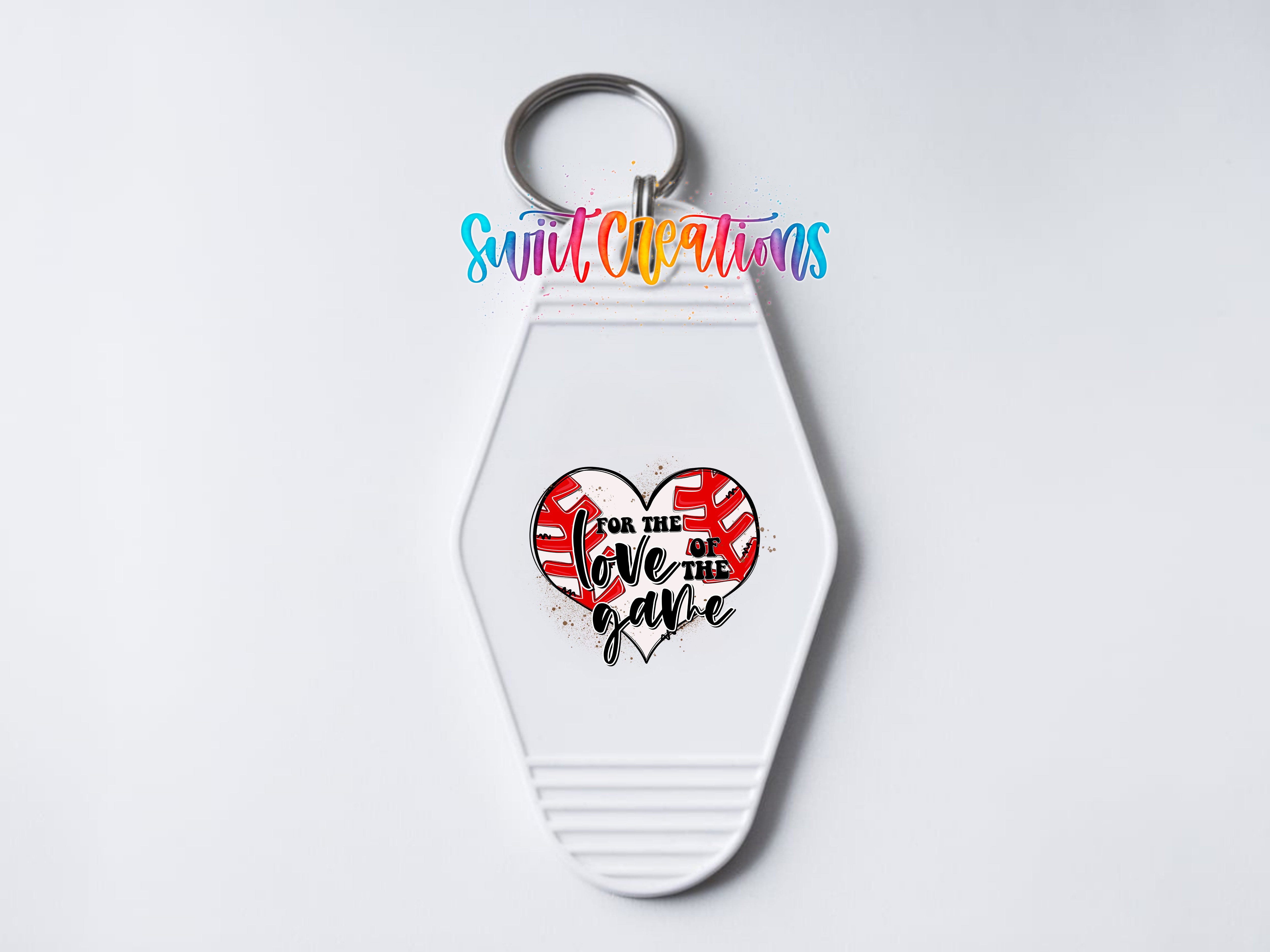 A white keychain with a heart-shaped design and text on it.