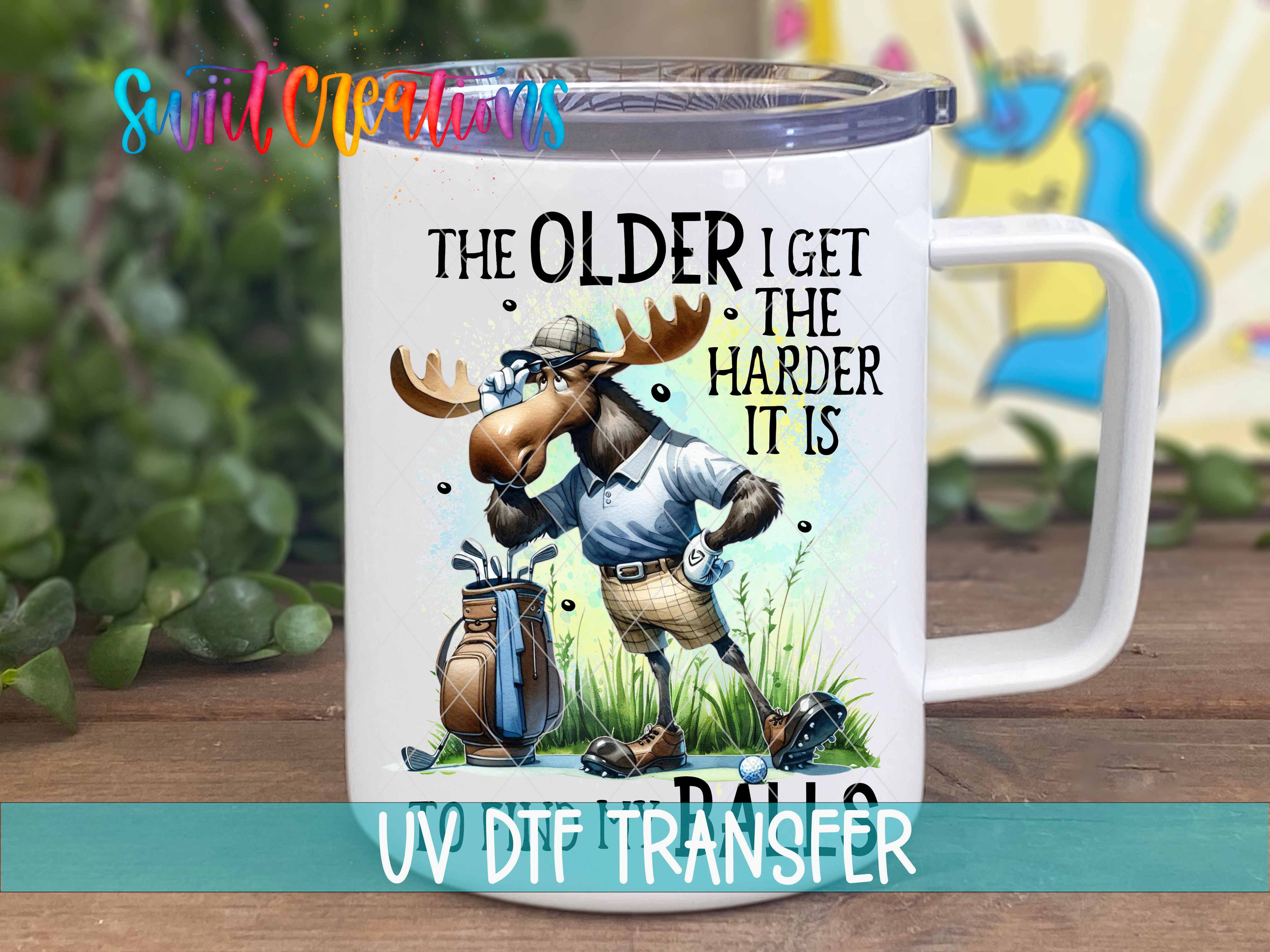 A mug with a cartoon moose wearing a golf outfit and holding a golf club, along with text that says "The older I get, the harder it is".