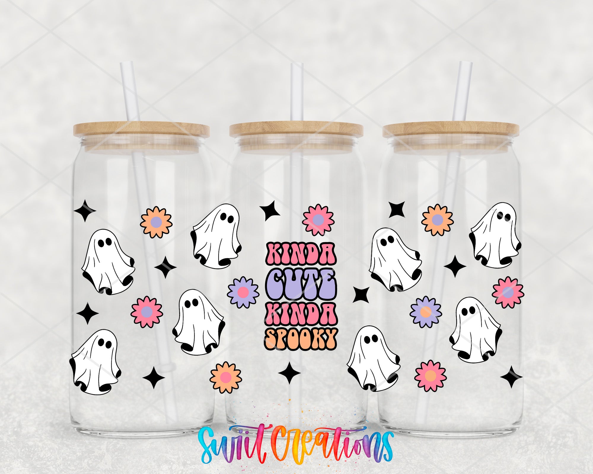 A trio of clear glass tumblers with wooden lids, each adorned with a whimsical design of ghostly figures and colorful flowers. The text "KINDA CUTE KINDA SPOOKY" is prominently displayed on the front of the tumblers, adding a playful and festive touch to the overall design.