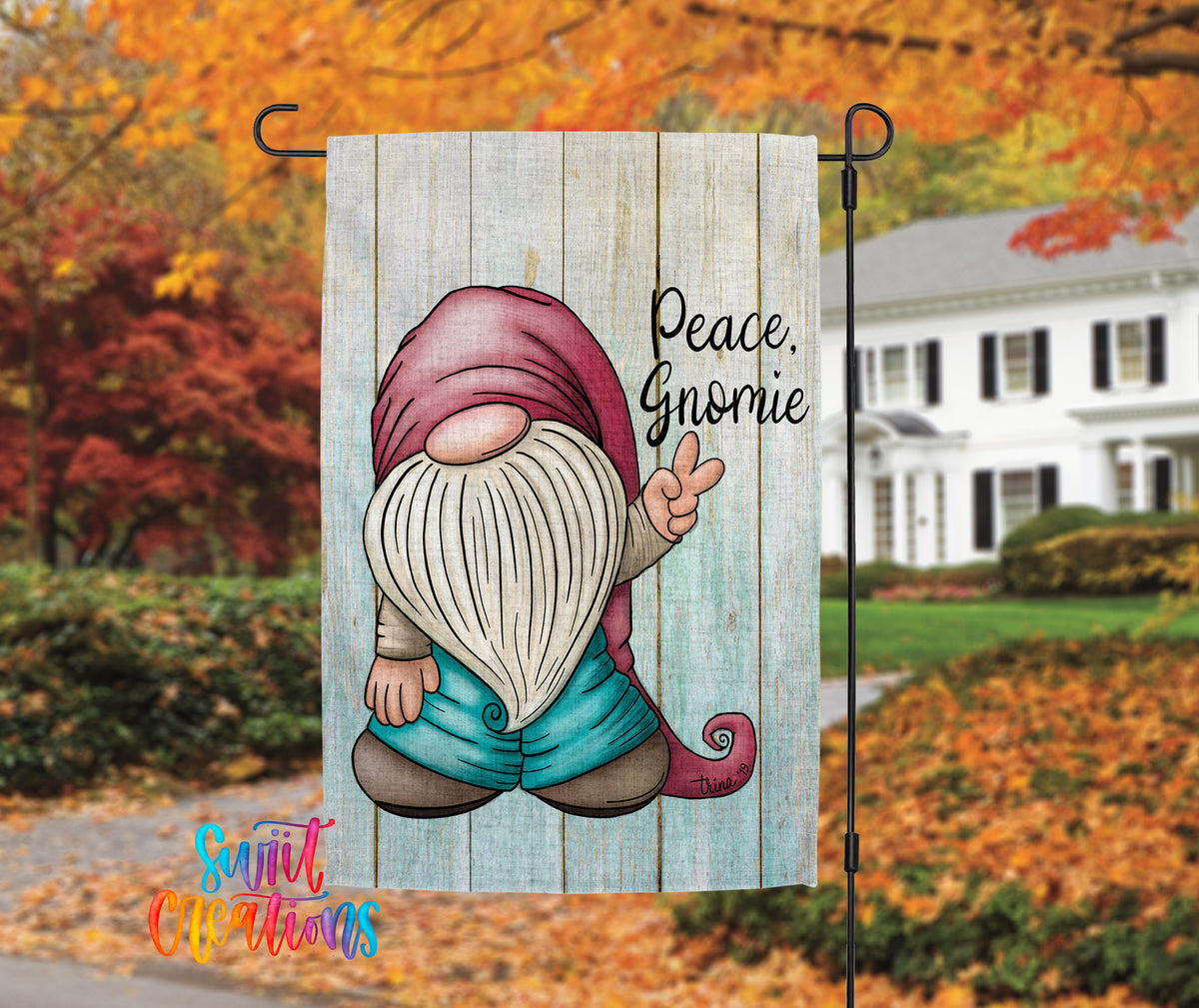 A colorful garden gnome sign with the text "Peace, Gnomeie" is displayed in front of a house with autumn foliage in the background.