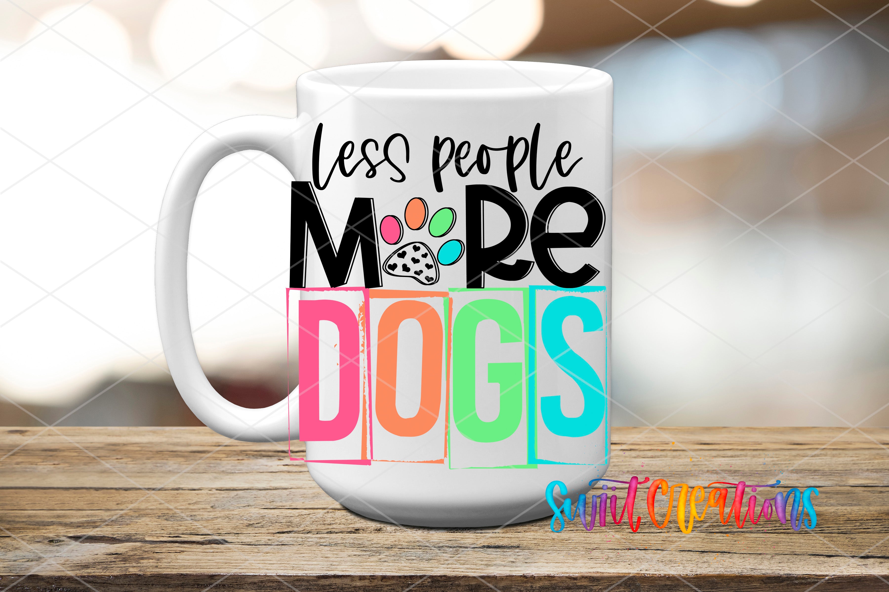 A white mug with colorful text and paw prints on it, placed on a wooden surface.