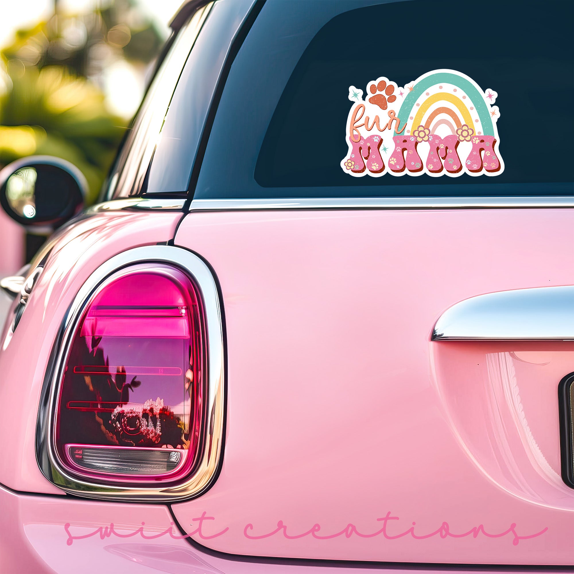 a pink car with a rainbow sticker on it