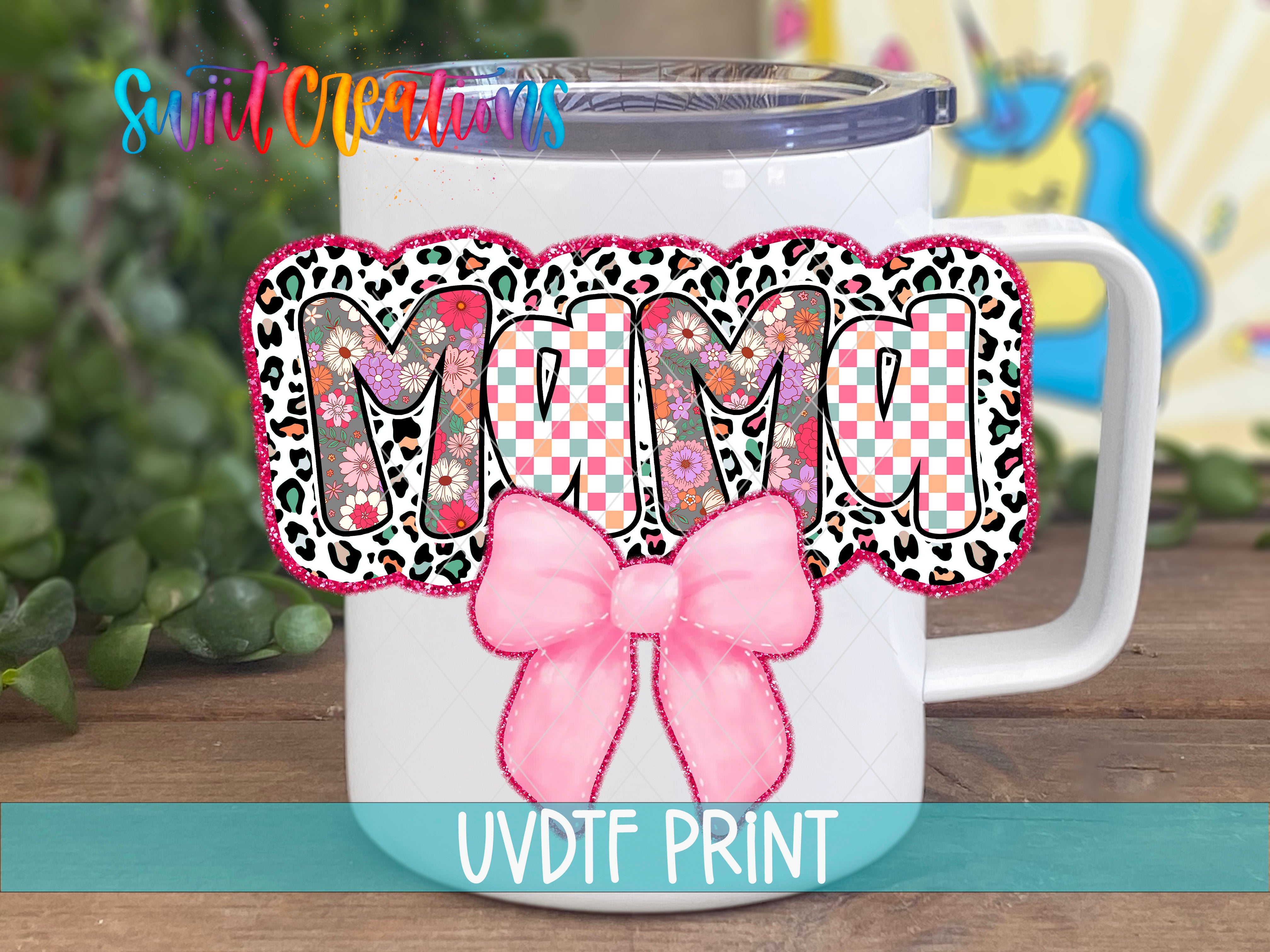 A white mug with a colorful leopard print design and a pink bow, along with the text "MAMA" and "UVDF PRINT" printed on it.