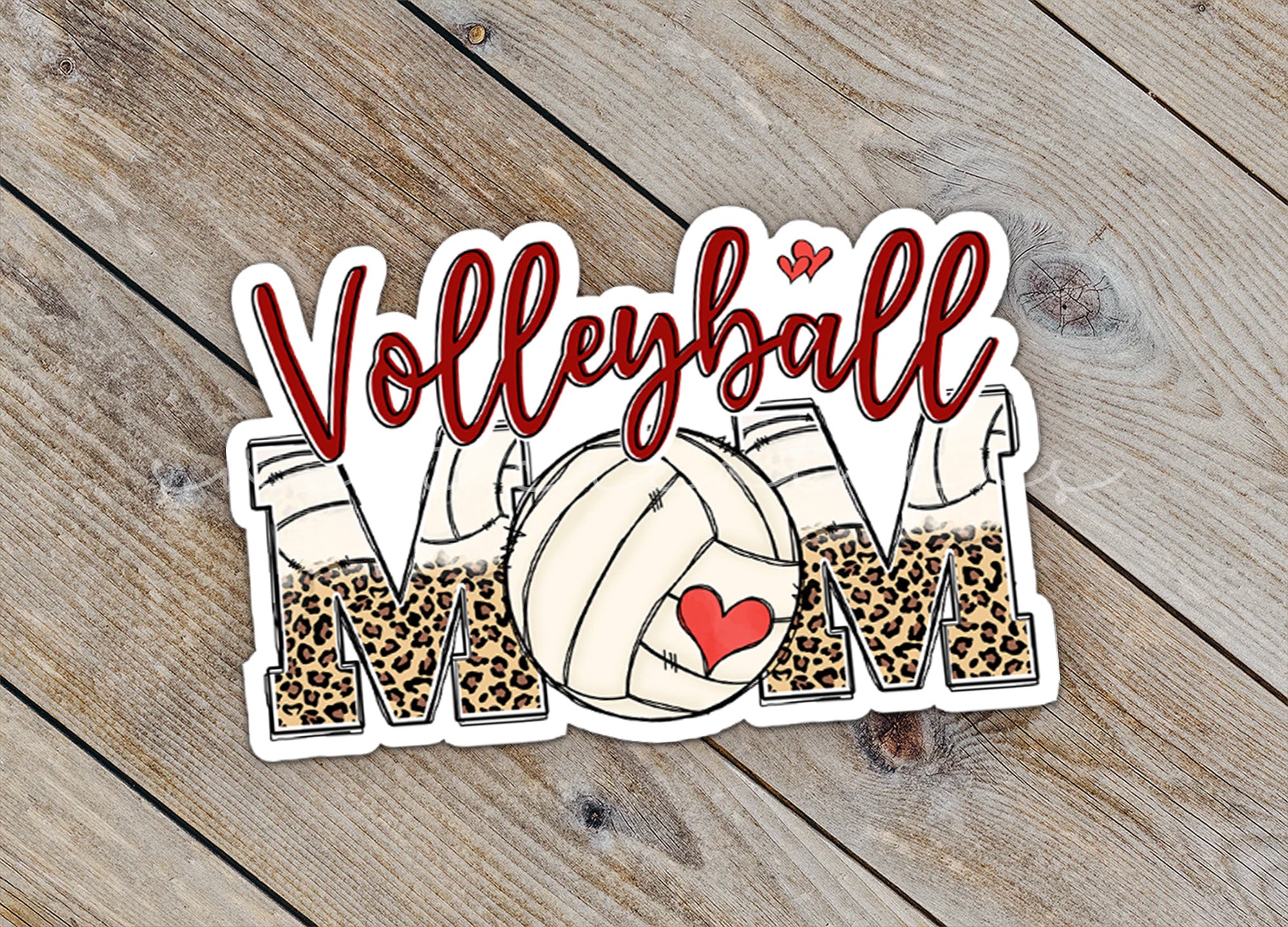 a volleyball mom sticker sitting on top of a wooden table