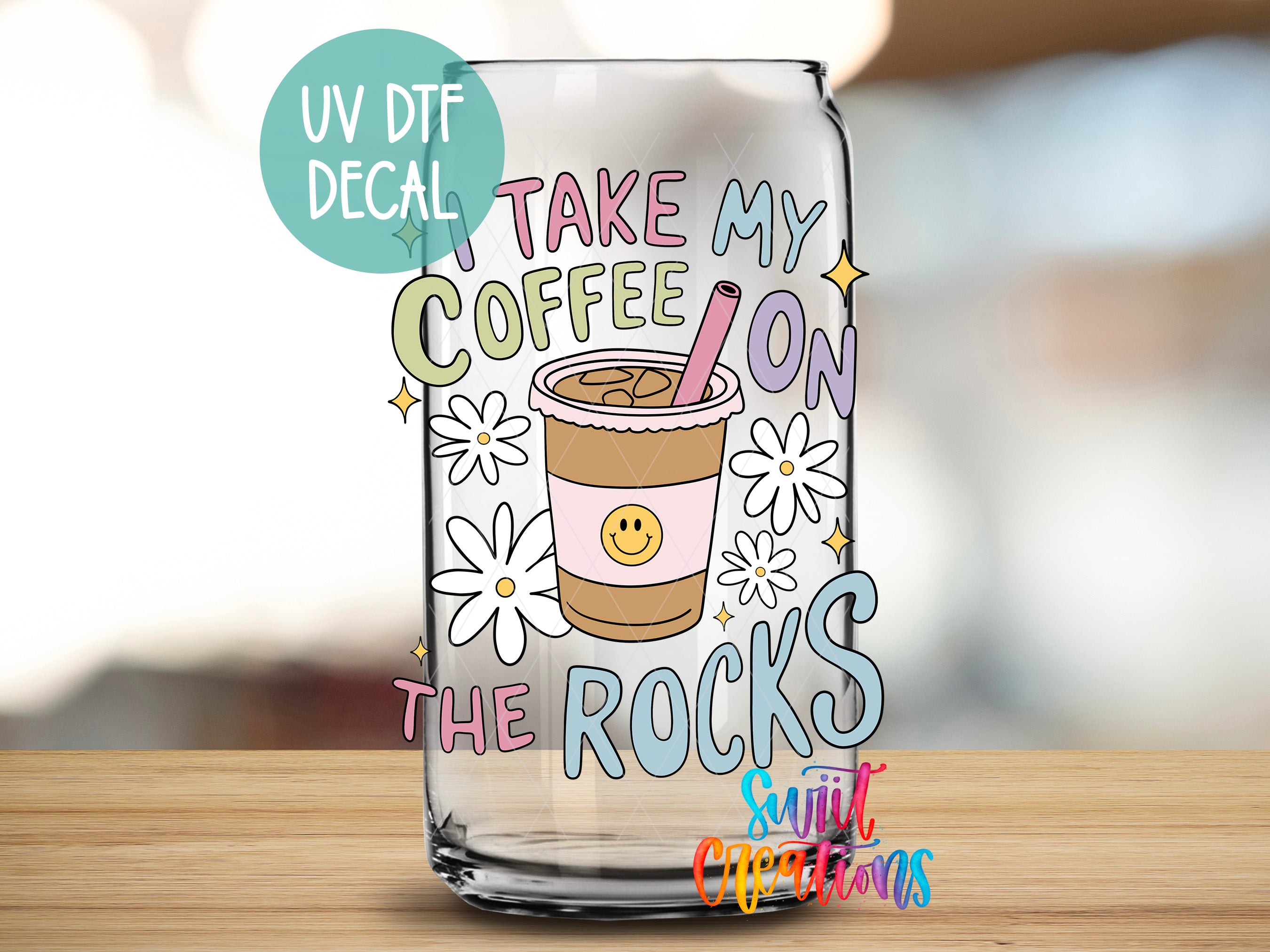 A glass can with a UV decal that says "Take my coffee on the rocks" and features a coffee cup with a smiley face and flowers.