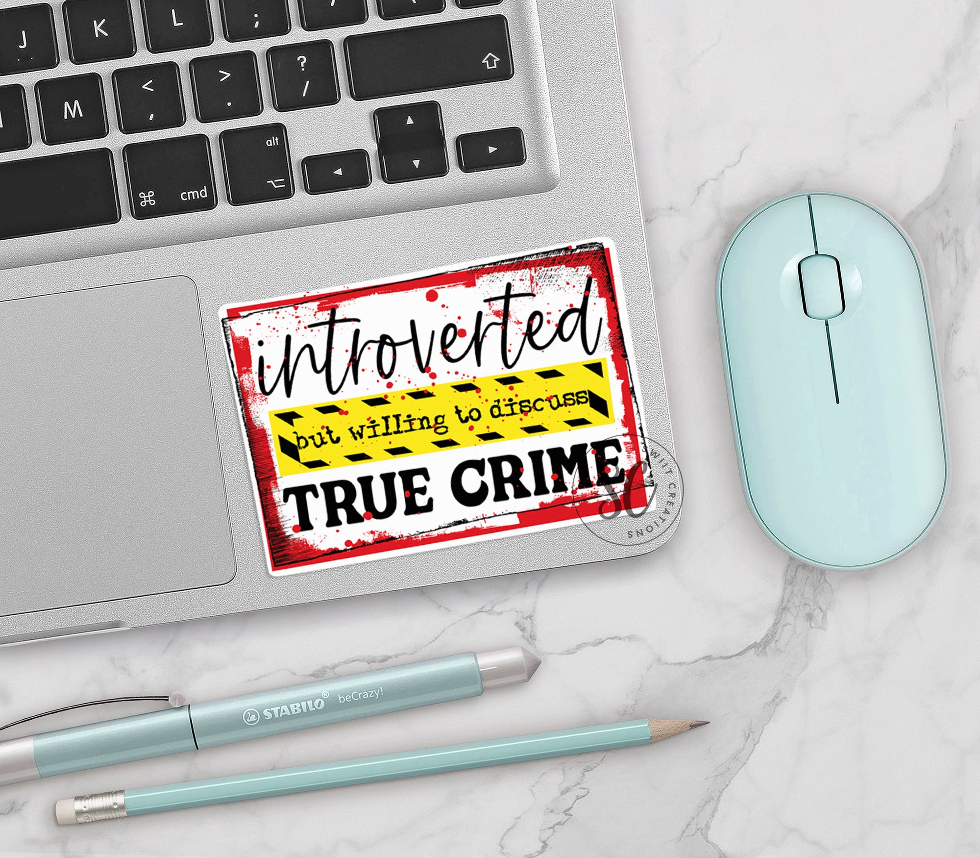 a sticker on a laptop next to a mouse