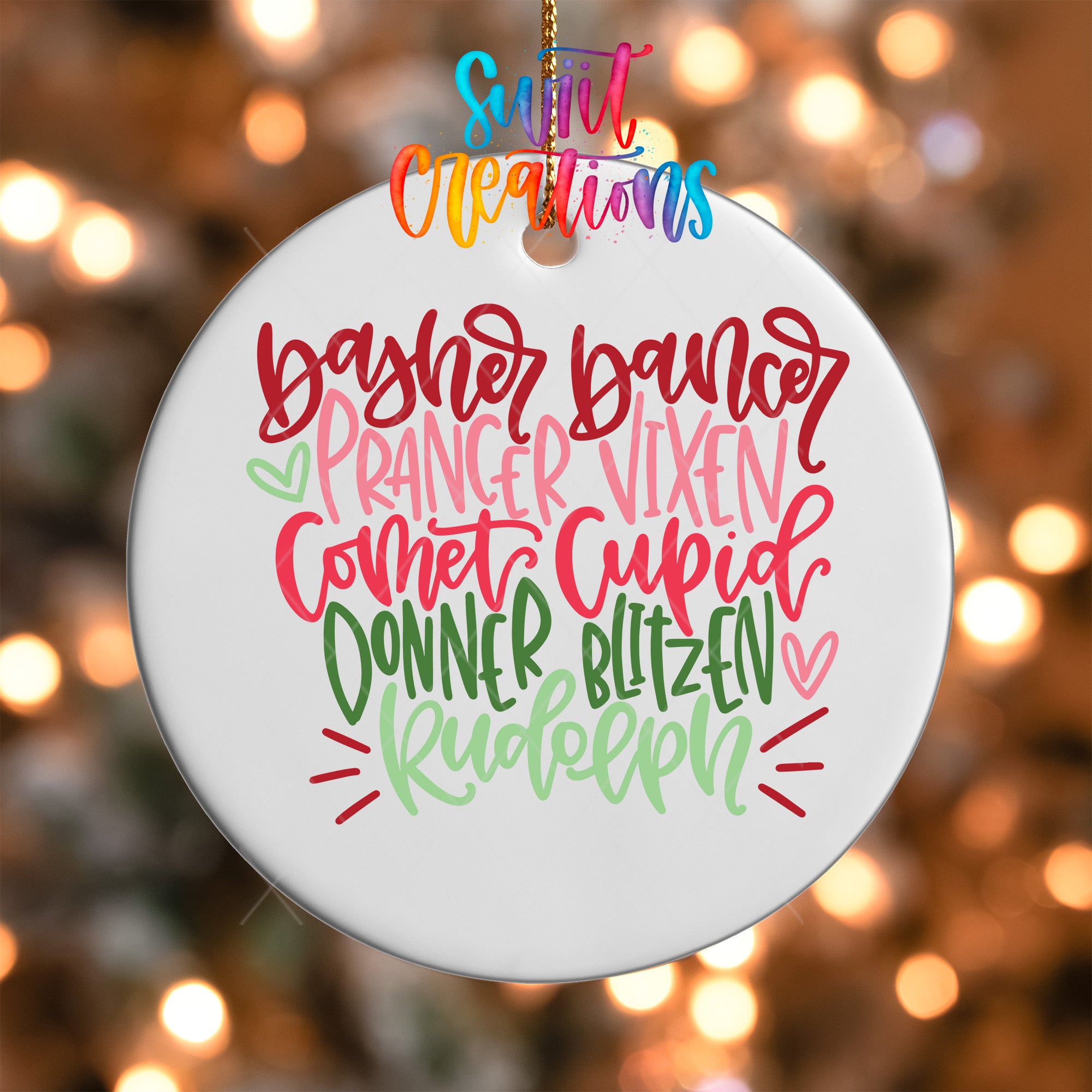A white ornament with colorful text that says "Bashir dancer Prancer Vixen Comet Cupid Donner Blitzen Rudolph" hanging on a string.