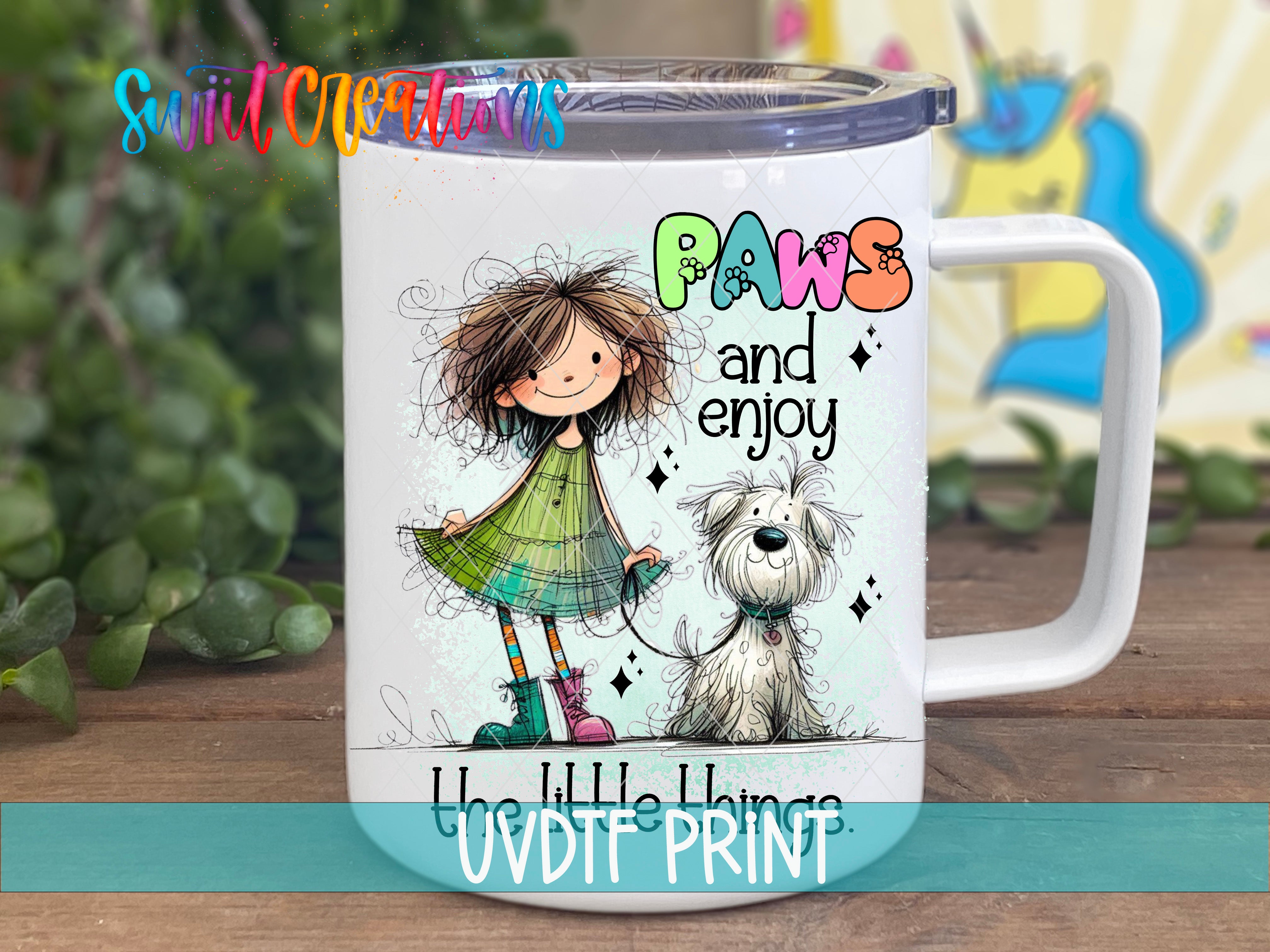 A white mug with a colorful illustration of a girl and a dog, along with the text "Paws and enjoy" and "The things" printed on it.