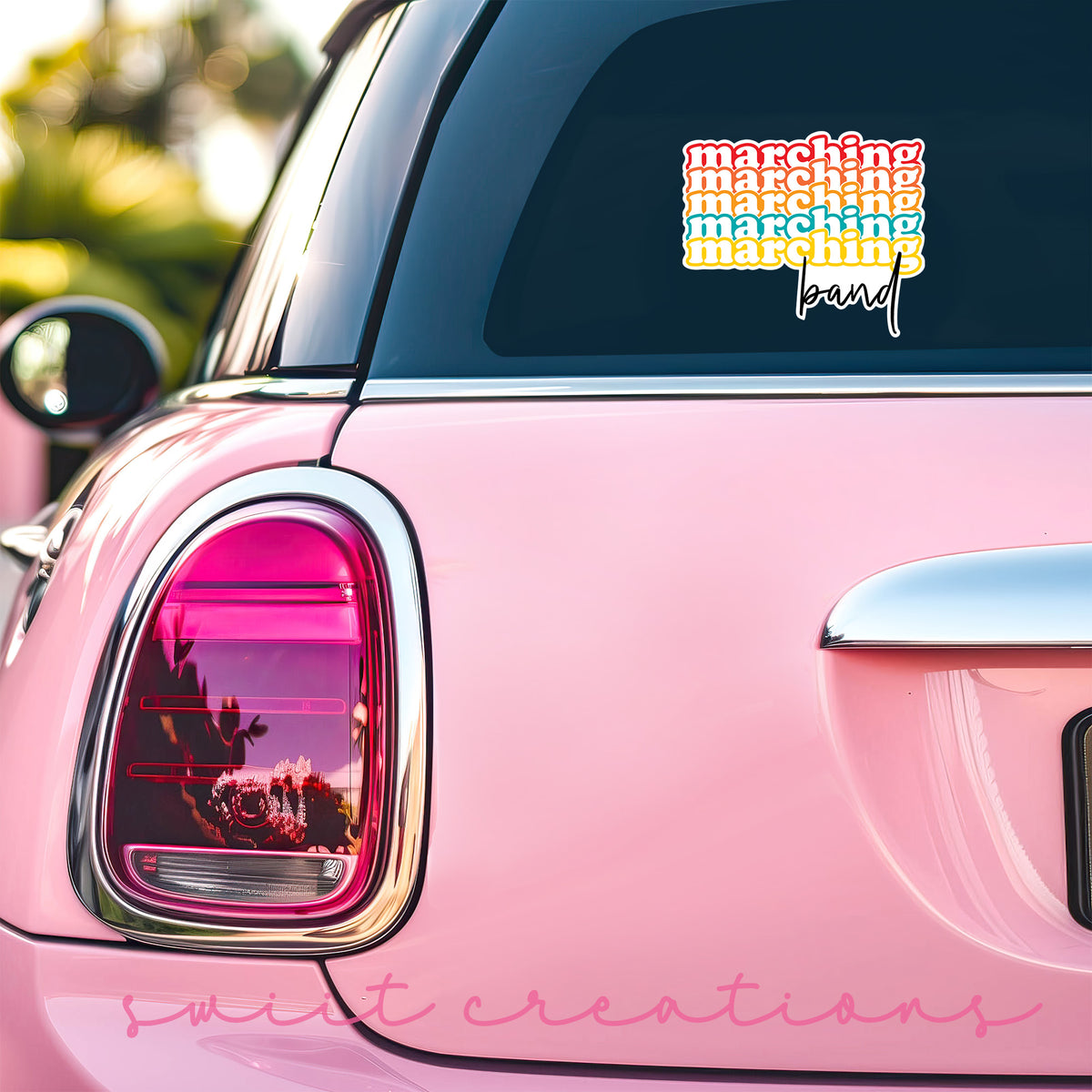 a pink car with a sticker on the back of it
