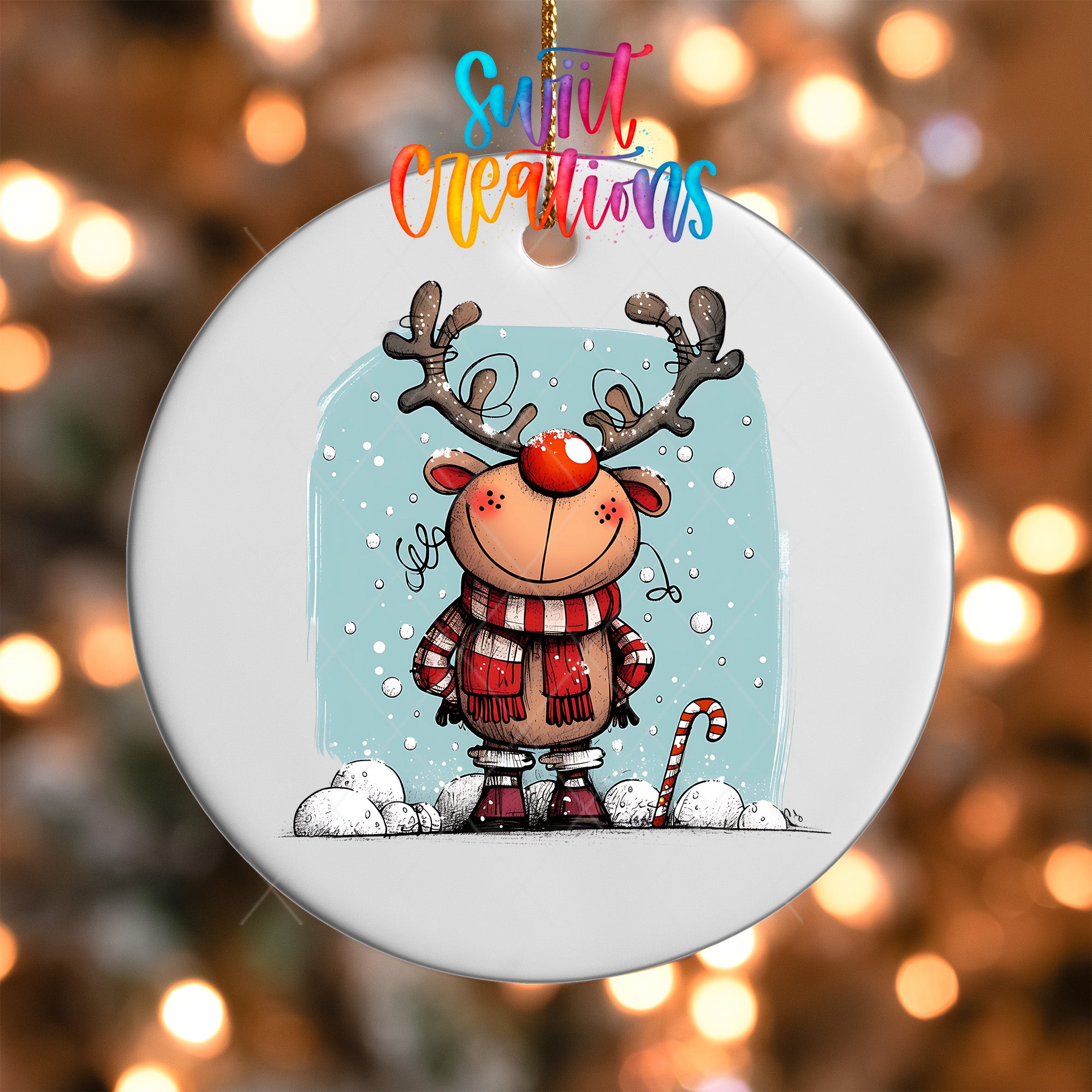 A white ornament featuring a cartoon reindeer with antlers and a red nose, surrounded by snow and a candy cane, against a background of colorful lights.