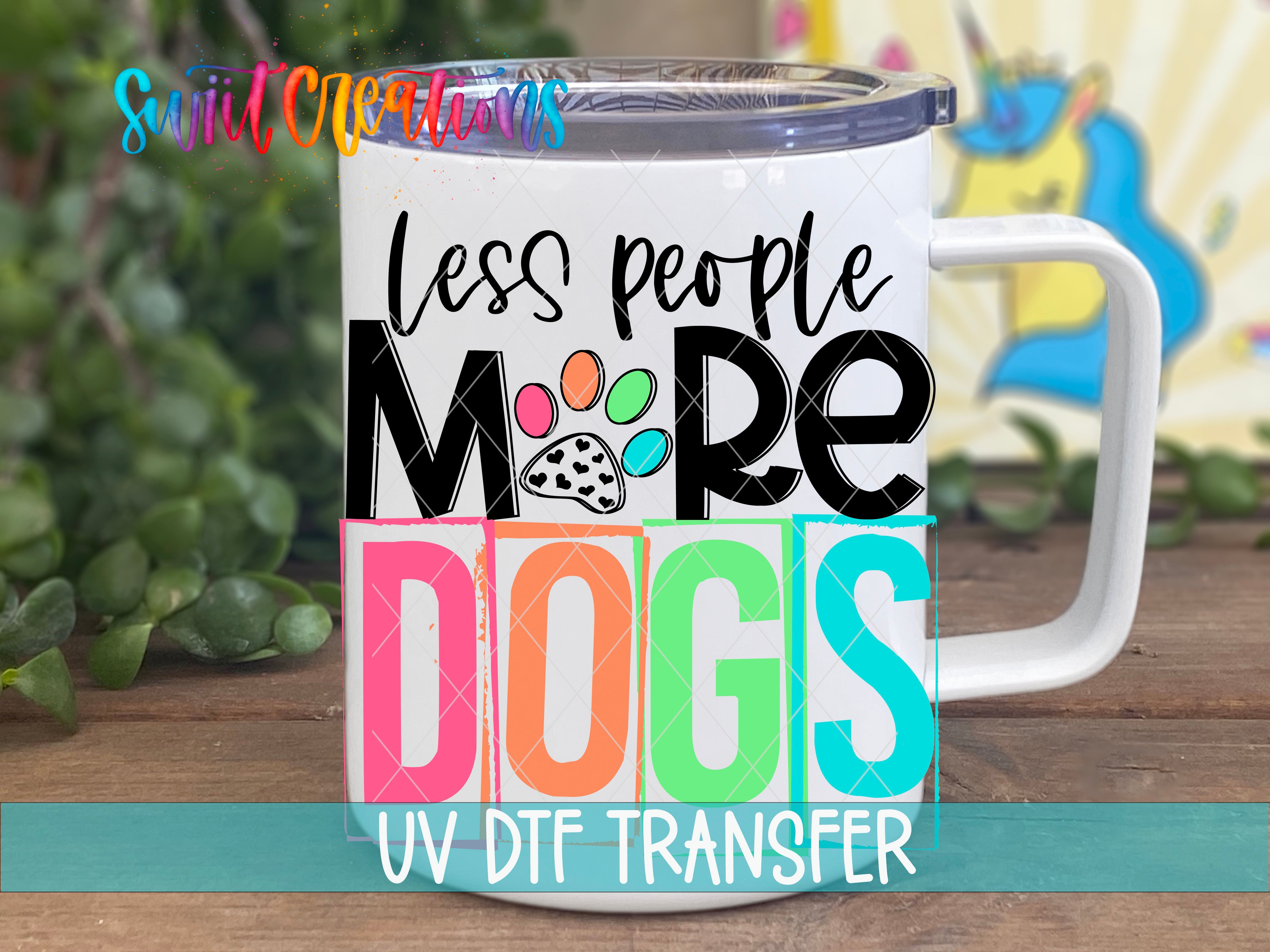 A white mug with a colorful design featuring the text "Less people, more dogs" and a paw print icon.