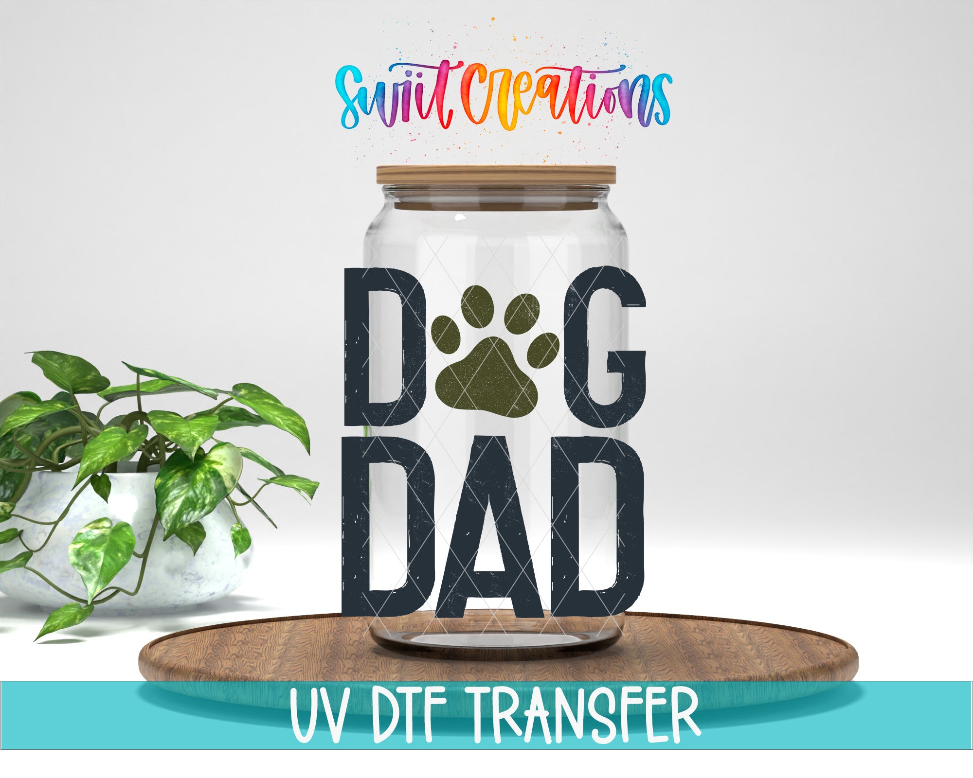 A glass jar with the word "DOG" and a paw print on it, placed on a wooden surface. There is also a potted plant in the background.